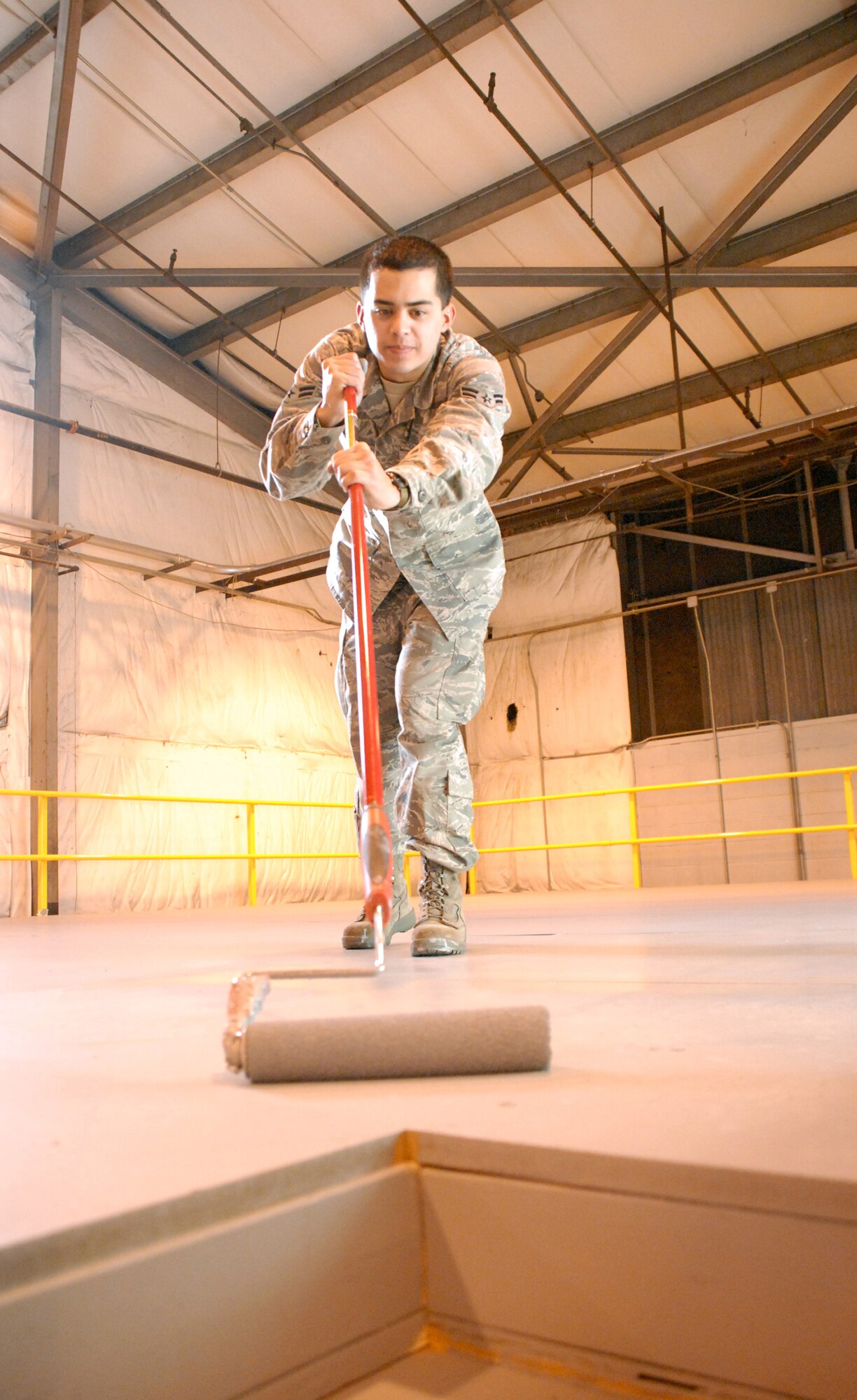Airman 1st Class Jonathan Erickson, 436th Aircraft Maintenance Squadron, paints the floor of the newly built mezzanine in Hangar 793. (U.S. Air Force photo/Airman 1st Class Shen-Chia Chu)