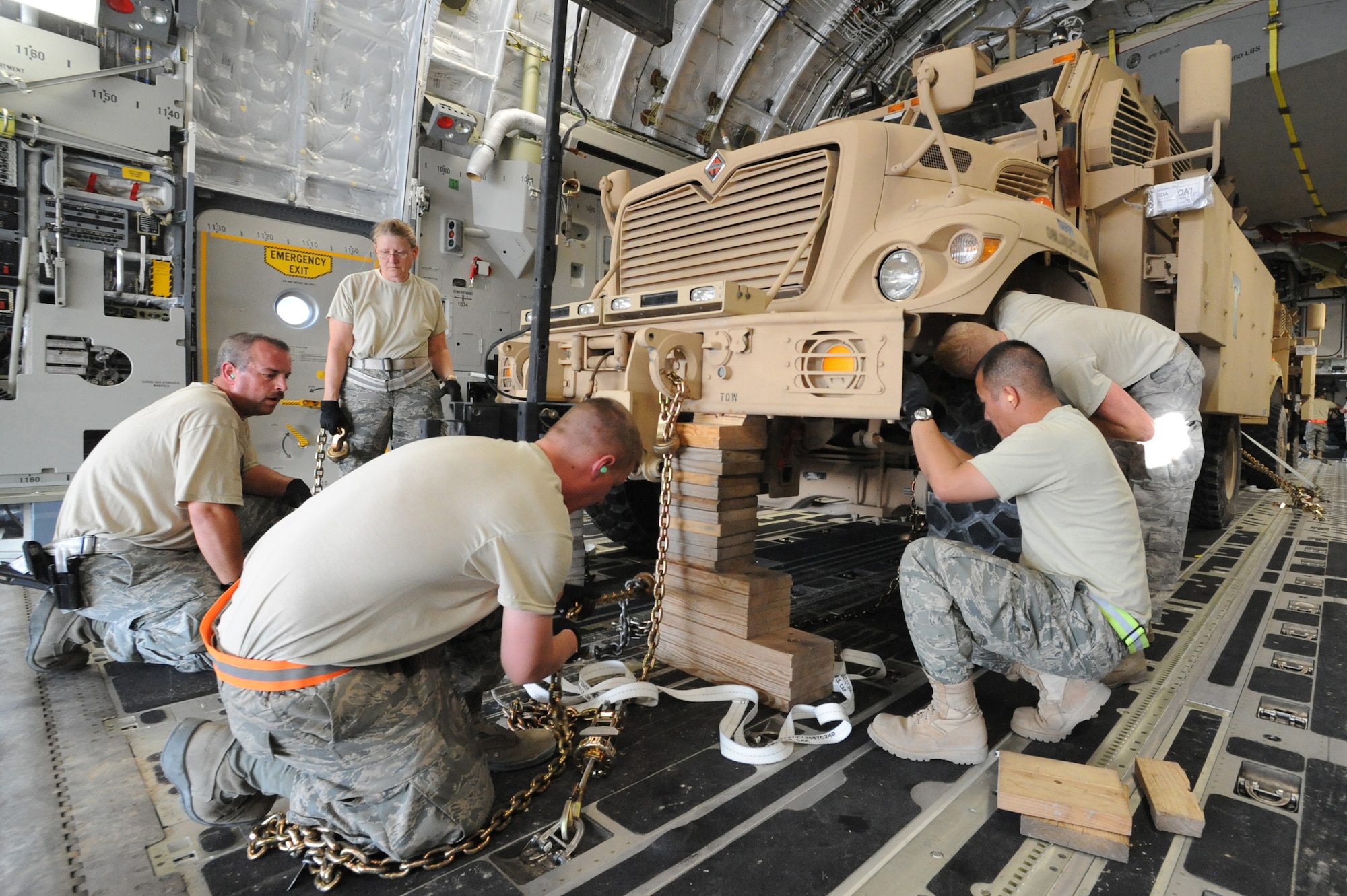 8th Expeditionary Air Mobility Squadron aerial port transporters strap down a Mine Resistant Ambush Protective vehicle inside a C-17 Globemaster III aircraft at a non-disclosed Southwest Asia location, Feb. 12, 2010. (U.S. Air Force photo by Tech. Sgt. Michelle Larche)[RELEASED]