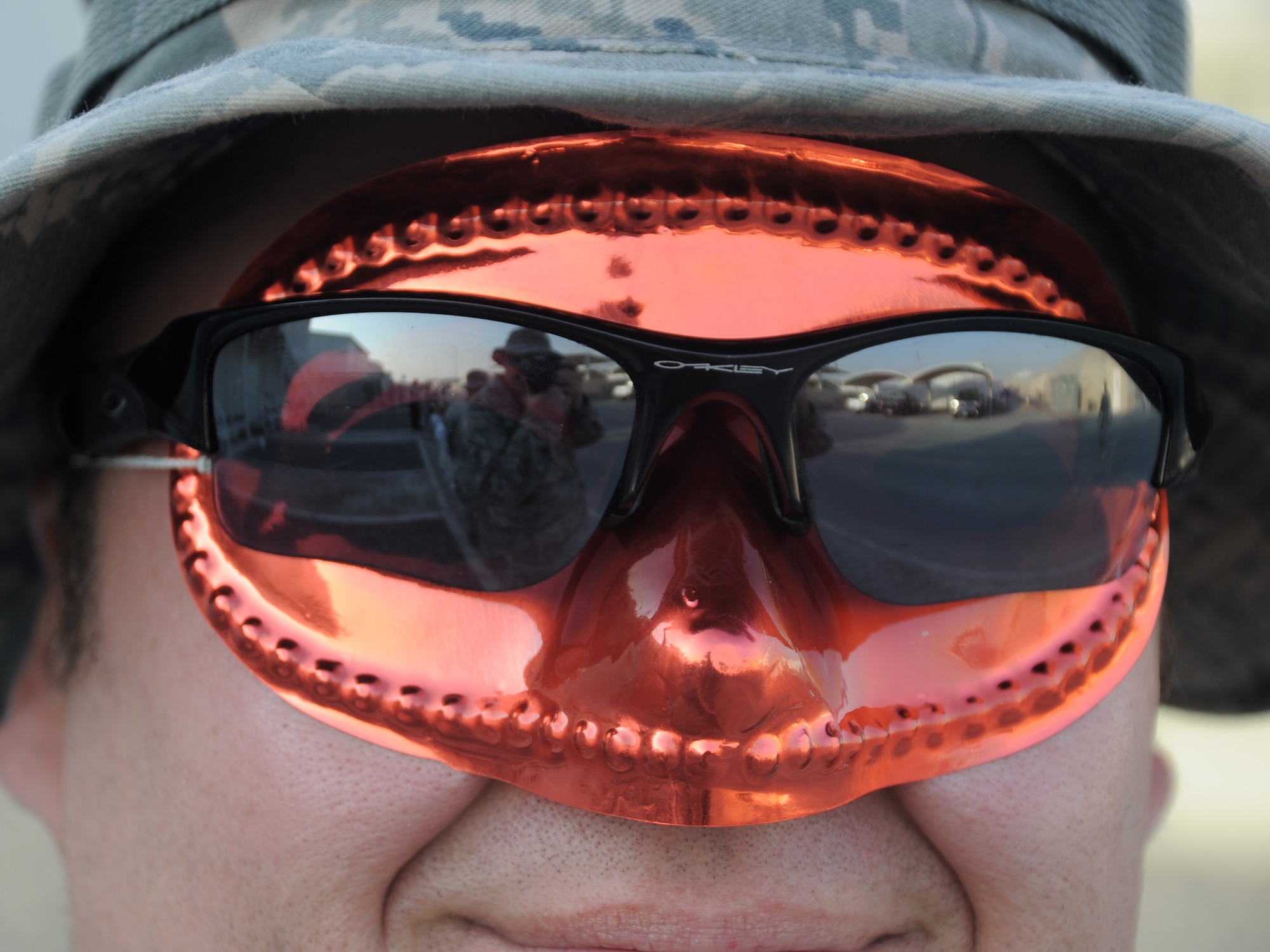 Master Sgt. Scott Sturkol, 380th Air Expeditionary Wing Public Affairs, is seen in the reflection of 380th AEW Tech. Sgt. William Huffmon's glasses during the 380th Air Expeditionary Wing Mardi Gras parade at an undisclosed location in Southwest Asia on Feb 16, 2010. The wing celebrated the holiday with a parade and cajun meal options at the dining facility.  The 380th AEW is comprised of four groups and 12 squadrons and the wing's deployed mission includes air refueling, surveillance, and reconnaissance in support of overseas contingency operations in Southwest Asia. The wing supports Operation Iraqi Freedom, Operation Enduring Freedom and the Combined Joint Task Force-Horn of Africa. (U.S. Air Force photo/Master Sgt. Scott Sturkol/Released)
