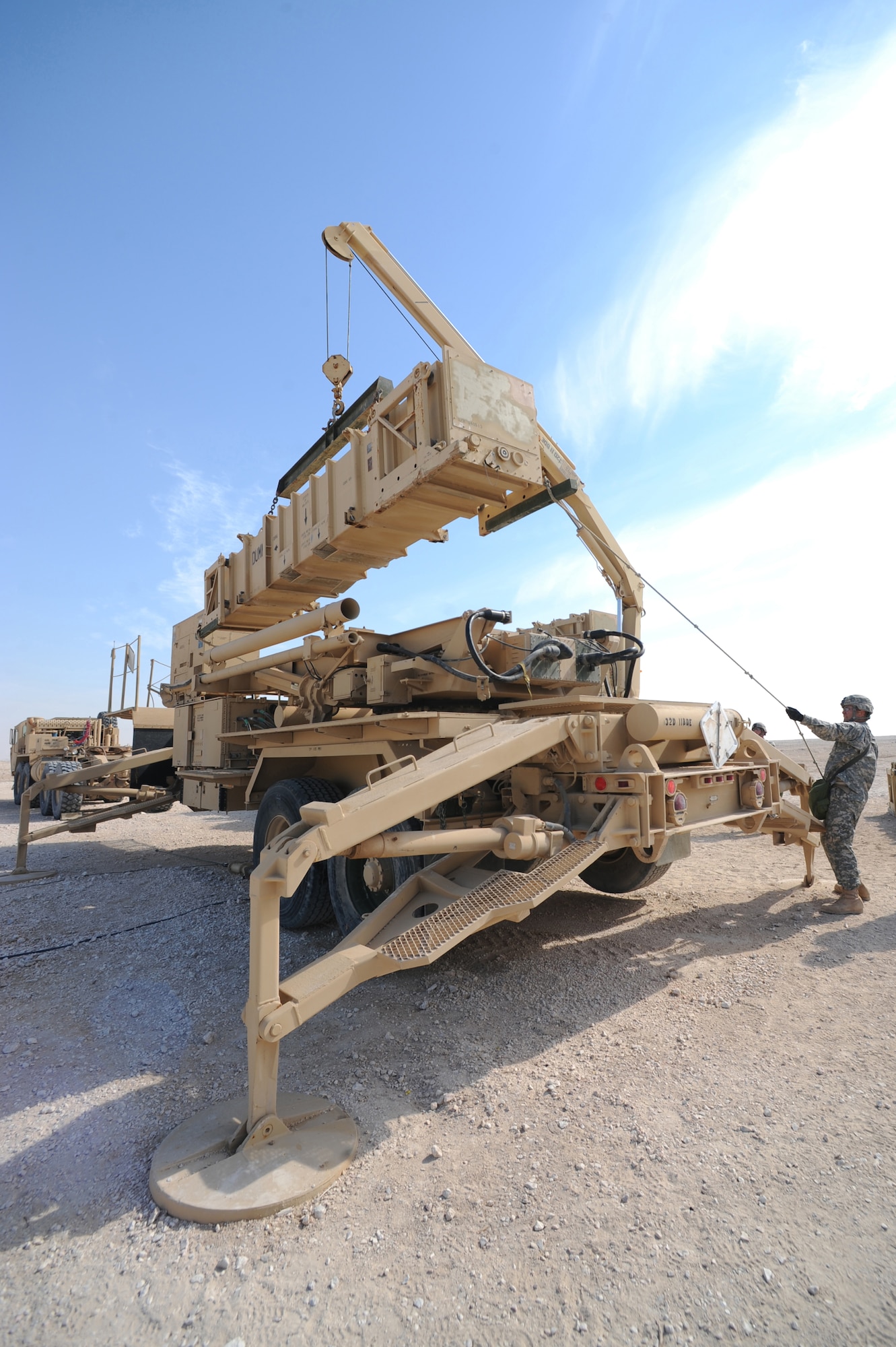 Army Staff. Sgt. James Huntington, Bravo Battery, 1-43 Air Defense Artillery, Patriot Launch Station operator/maintainer, holds a tag line to keep a missle canister steady during a guided-missle transporter reload certification activity at a non-disclosed Southwest Asia location, Feb. 12, 2010. (U.S. Air Force photo by Tech. Sgt. Michelle Larche)[RELEASED]