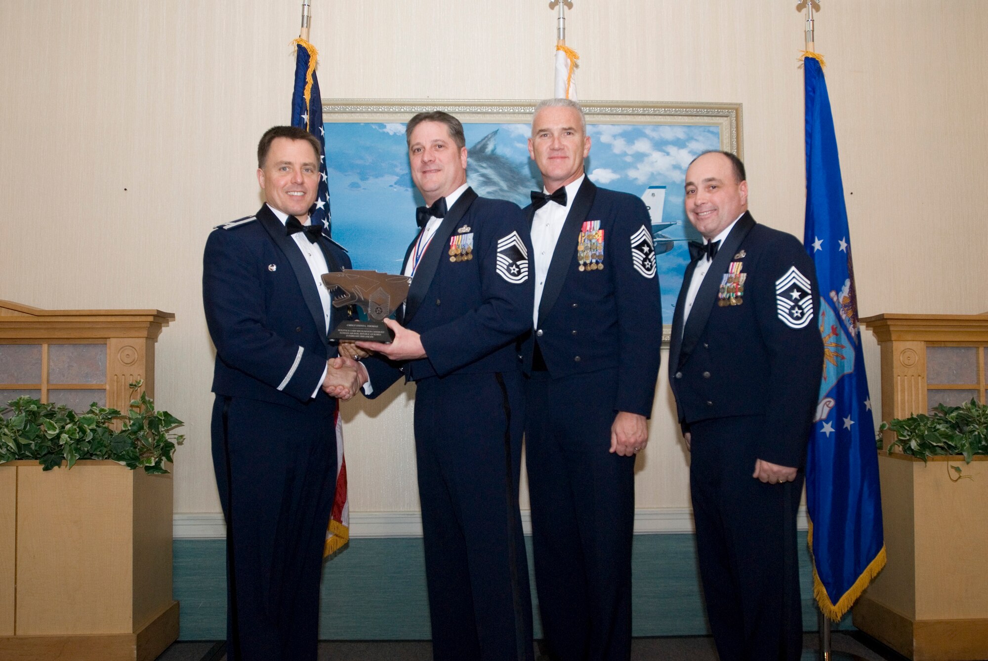 KUNSAN AIR BASE, Republic of Korea-(left to rt.) Col. Robert Givens presents a plaque to Chief Master Sgt. Steven Thomas along with Command Chief Master Sgt. Brooke McLean, PACAF, and Command Chief Master Sgt. James Sanders, 8th FW, during the chief master sergeant induction ceremony, here, Feb. 13. The purpose of the induction ceremony was to celebrate and recognize the four new chiefs being promoted in the Wolf Pack. (U.S. Air Force photo/Senior Airman Jonathan Steffen)

