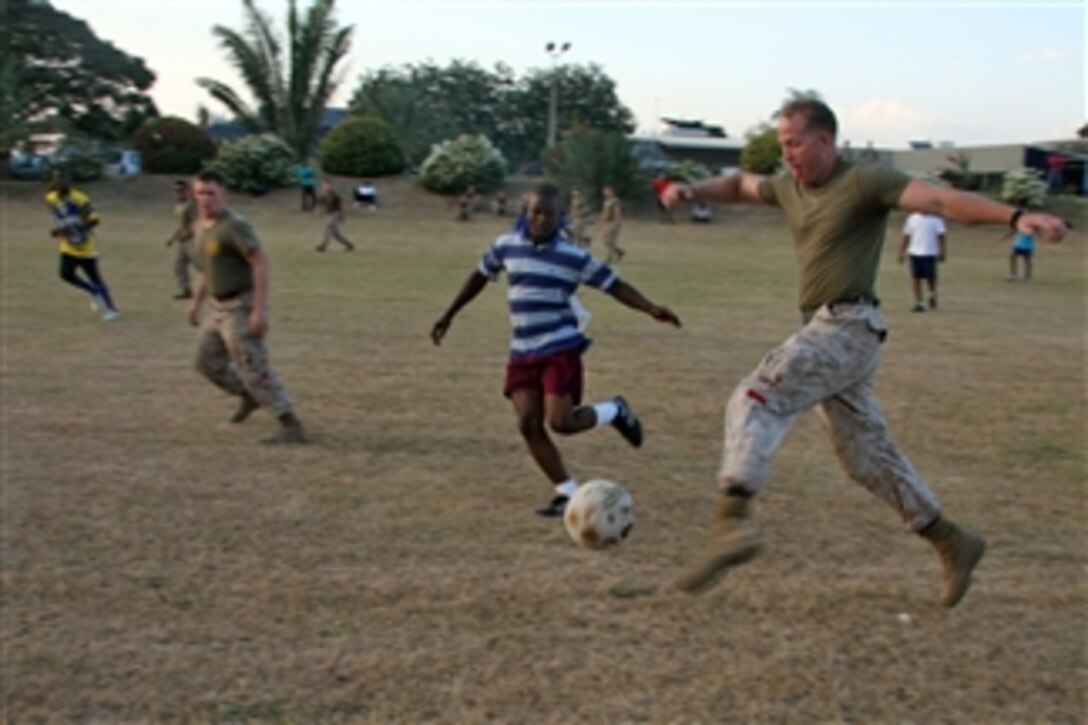 U.S. Marines with Combat Logistics Battalion 24, 24th Marine Expeditionary Unit play a game of soccer with Haitian residents at a field alongside the interim aftercare facility in Port-au-Prince, Haiti, on Feb. 5, 2010.  Marines of Combat Logistics Battalion 24 set up this aftercare facility for medically treated earthquake victims returning from the USNS Comfort (T-AH 20) to their homes in Haiti.  