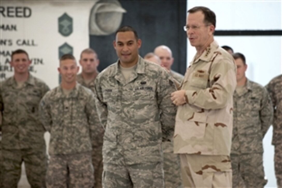 U.S. Navy Adm. Mike Mullen, chairman of the Joint Chiefs of Staff, prepares to re-enlist Senior Airman Jams Pabon and 19 fellow servicemembers before an all-hands call with the 380th Air Expeditionary Group in Southwest Asia, Feb. 18, 2010. Mullen is touring the region, visiting with key partners and allies.