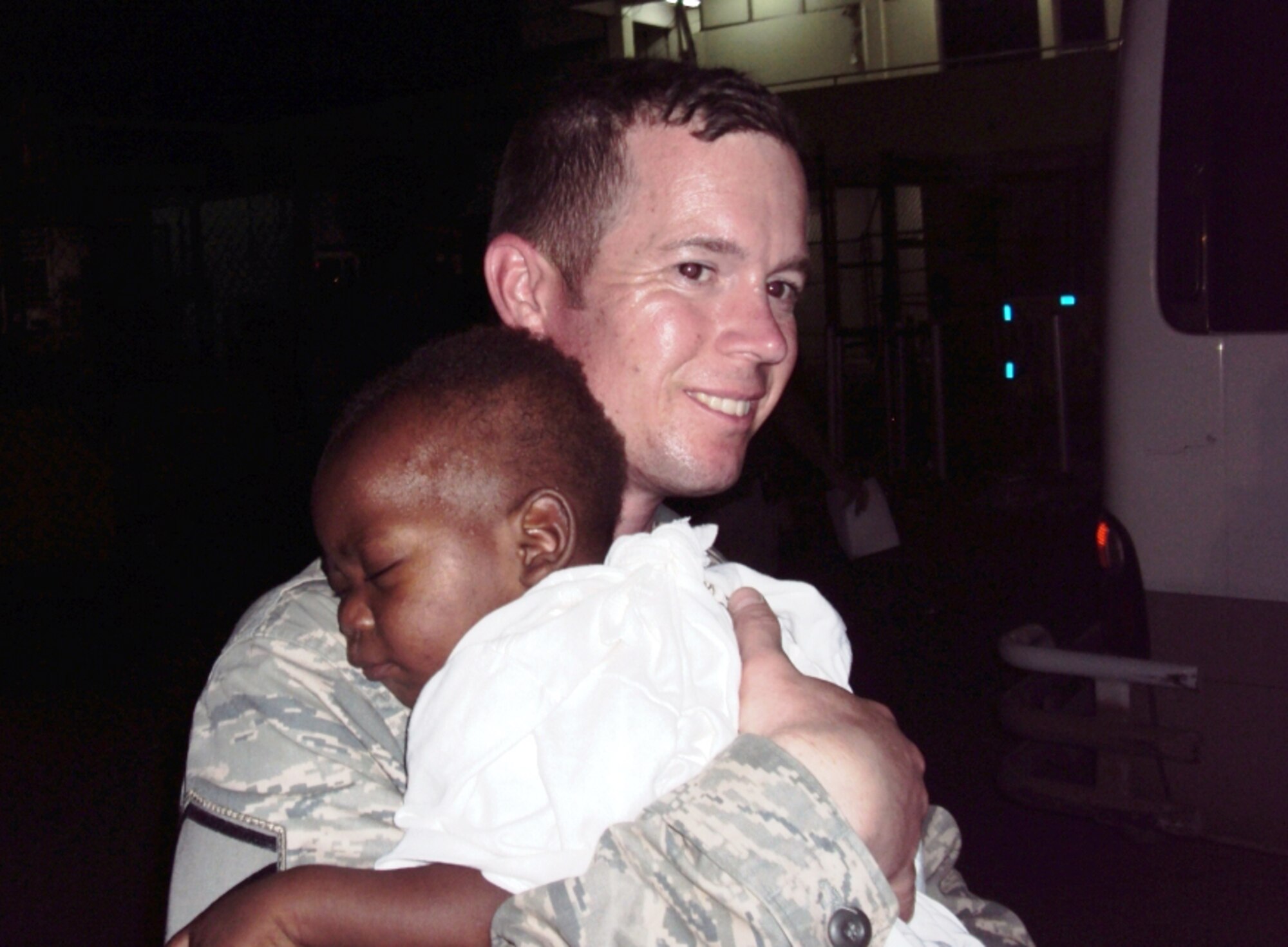 MOUNTAIN HOME AIR FORCE BASE, Idaho --Master Sgt. Jerol Boyce holds a Haitian child. He deployed to Haiti Feb. 2 to serve as the 24th Air Expeditionary Group law office manager. (Courtesy photo)