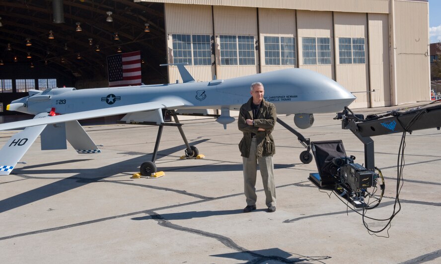HOLLOMAN AIR FORCE BASE, N.M. -- Retired U.S. Marine Lt. Col. Oliver North with the Fox News Channel films a scene in front of an MQ-1 Predator, Feb. 18, for a documentary on the Air Force's Remotely Piloted Aircraft mission. The FNC crew was filming part of the series called "War Stories with Oliver North." (U.S. Air Force photo by Tech. Sgt. Alan Port)(Released)