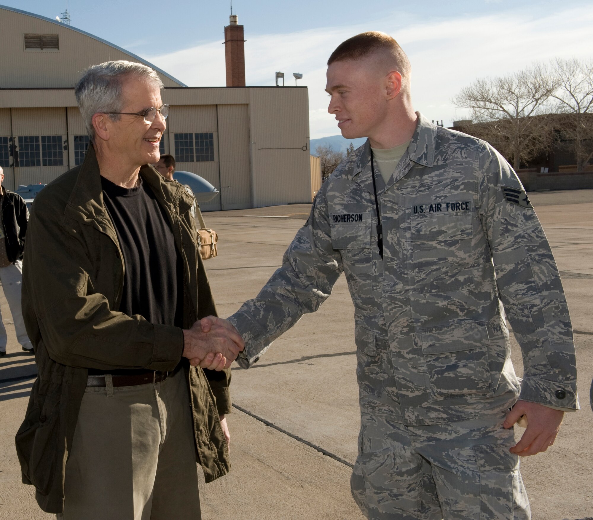 HOLLOMAN AIR FORCE BASE, N.M. -- Retired Marine Lt. Col. Oliver North shakes the hand of Senior Airman Christopher Richerson, 849th Aircraft Maintenance Squadron, Feb. 18 while filming a documentary on the Air Force's Remotely Piloted Aircraft mission. Mr. North was congratulating Airman Richerson on his recent below-the-zone promotion to senior airman.  (U.S. Air Force photo by Tech. Sgt. Alan Port)(Released)
