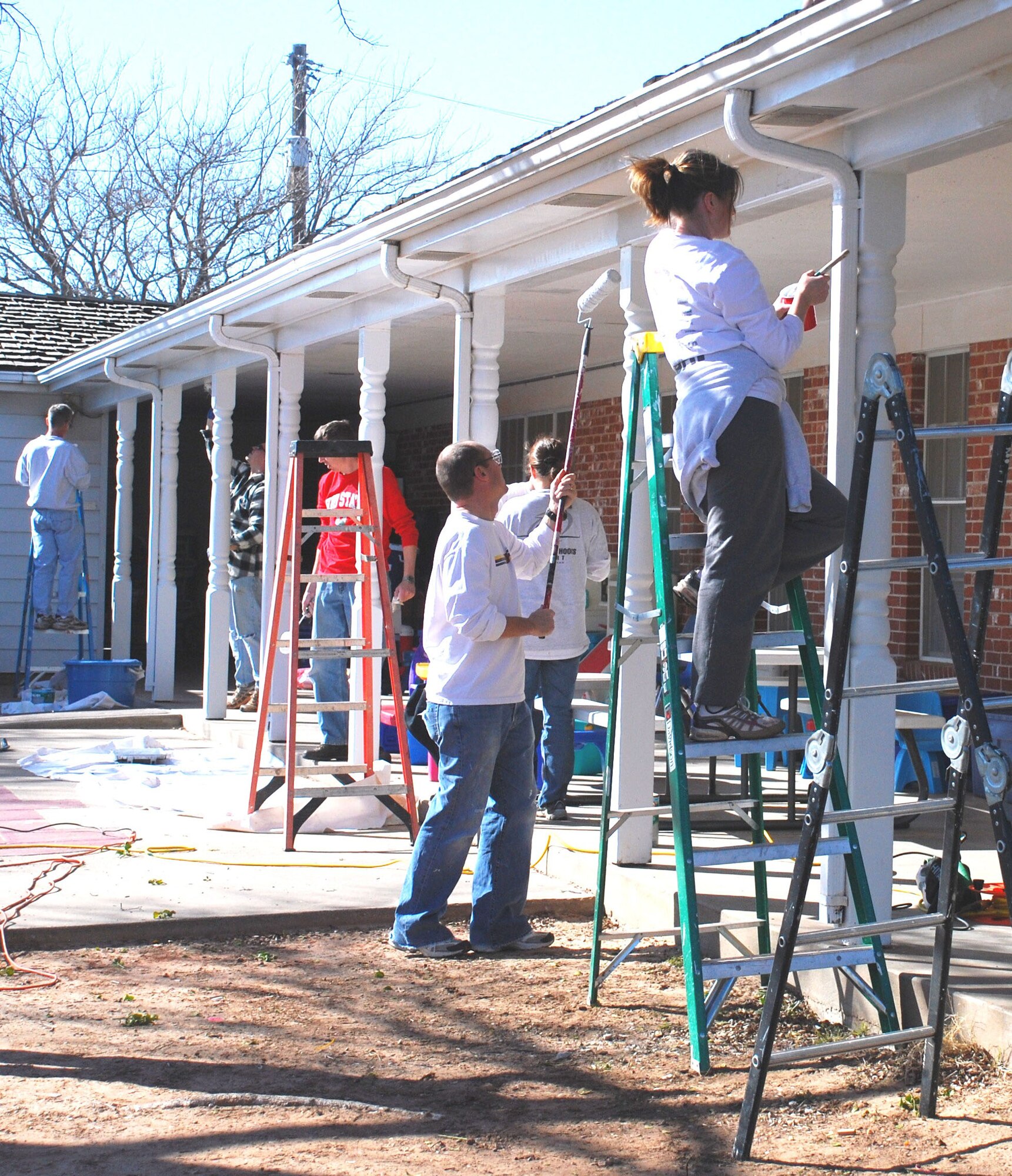 Members of the 97th Flying Training Squadron repaint the patio at the Children?s Home & Teen Emergency Shelter in Wichita Falls, Texas, Feb. 18. Volunteers trimmed trees; refurbished bicycles; painted the gymnasium, gazebo and back patio; resurfaced the playground and reinforced the back yard bridge. (U.S. Air Force photo/Airman 1st Class Valerie Hosea)