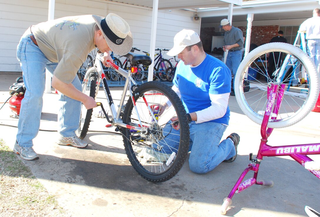 Maj. Scott Tate (left), a T-6 instructor pilot, and Lt. Col. Jeff Grayson (right),  the pilot instructor training flight commander, from 97th Flying Training Squadron, refurbished children?s bicycles at the Children?s Home & Teen Emergency Shelter in Wichita Falls, Texas, Feb. 18. Members of the 97th FTS who volunteered  also trimmed trees; painted the gymnasium, gazebo and back patio; resurfaced the playground and reinforced the back yard bridge. (U.S. Air Force photo/Airman 1st Class Valerie Hosea)