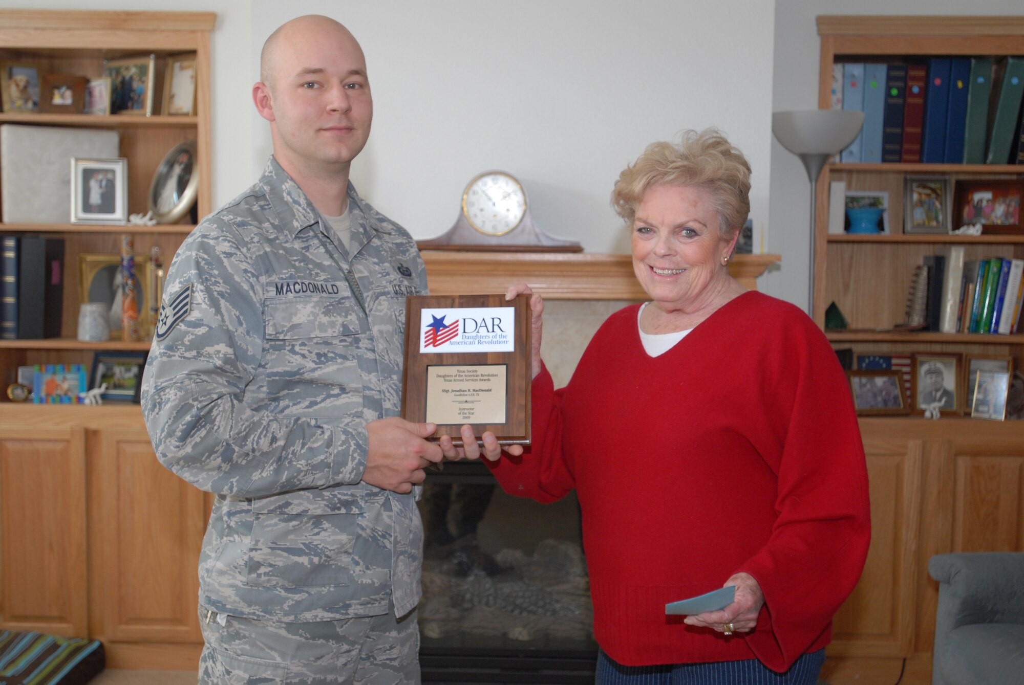 Staff Sgt. Johnathan MacDonald, 315th Training Squadron, Geospatial Intelligence Analyst Course, E-Flight instructor, is presented a 2009 Instructor of the Year plaque from Carol Smith, Texas Society state chairman of the Daughters of the American Revolution. Sergeant MacDonald was also given a $100 check. The DAR, founded in 1890 and headquartered in Washington, D.C., is a non-profit, non-political volunteer women's service organization dedicated to promoting patriotism, preserving American history, and securing America's future through better education for children. (U.S. Air Force photo/ Senior Airman Tong Duong)