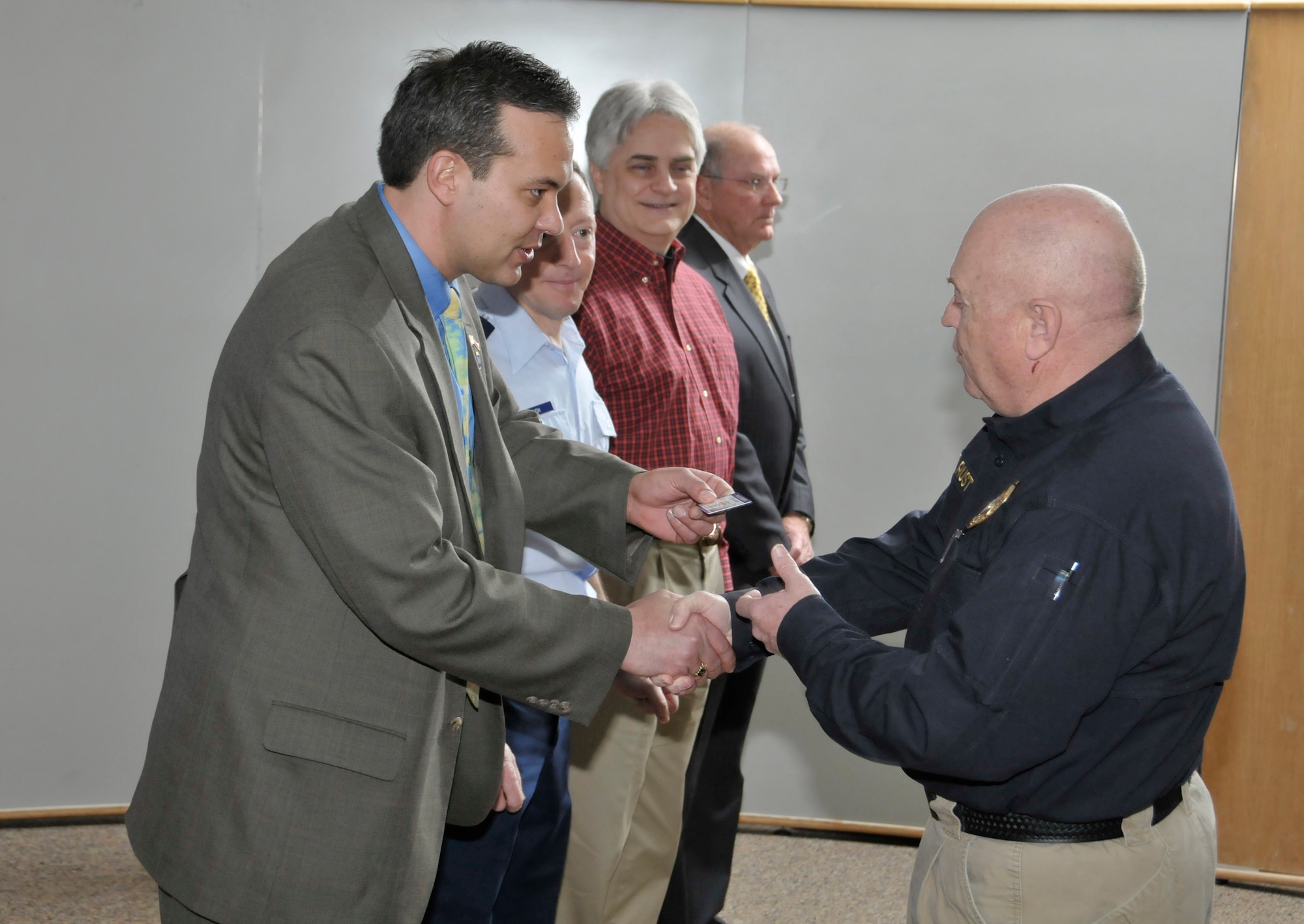 Tennessee State Rep. Judd Matheny, left, hands Officer Tommy Rust his commission card as Arnold Engineering Development Center Vice Commander Col. Eugene Mittuch, Aerospace Testing Alliance General Manager Dr. David Elrod and former AEDC Police of Chief Joe Kirk look on. Rep. Matheny played an integral role in helping Arnold Air Force Base become a Police Officer Standards and Training certified organization. (Photo by Rick Goodfriend)
