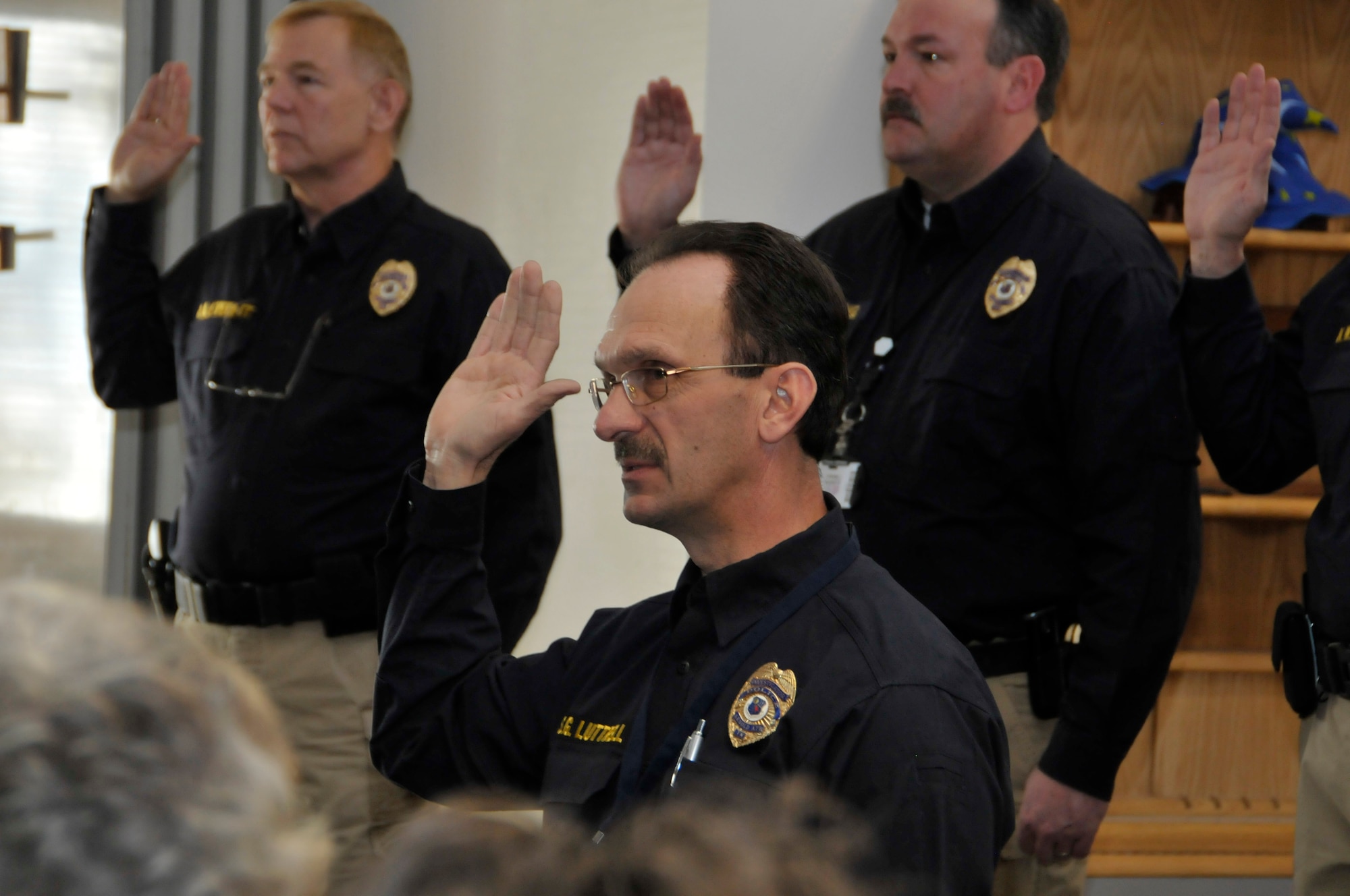 Arnold Air Force Base police officer Steve Luttrell, middle, recites the official police oath during a Police Officer Standards and Training certification event at the base Feb. 19. Officers Dave Everett, left, and Buck Young also recite the oath. (Photo by Rick Goodfriend)