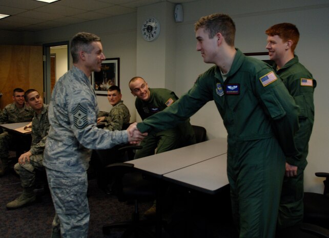 Chief Master Sgt. David Spector shakes hands with Airman 1st Class Austin Honeycutt at the First Term Airmen Center here during a base tour Feb. 17. During the chief's visit, he offered words of wisdom to the Airmen on how to have a successful Air Force career and the importance of setting reasonable goals. Chief Spector is the command chief of Air Mobility Command, and Airman Honeycutt is a loadmaster with the 15th Airlift Squadron. (U.S. Air Force Photo/Airman 1st Class Lauren Main)