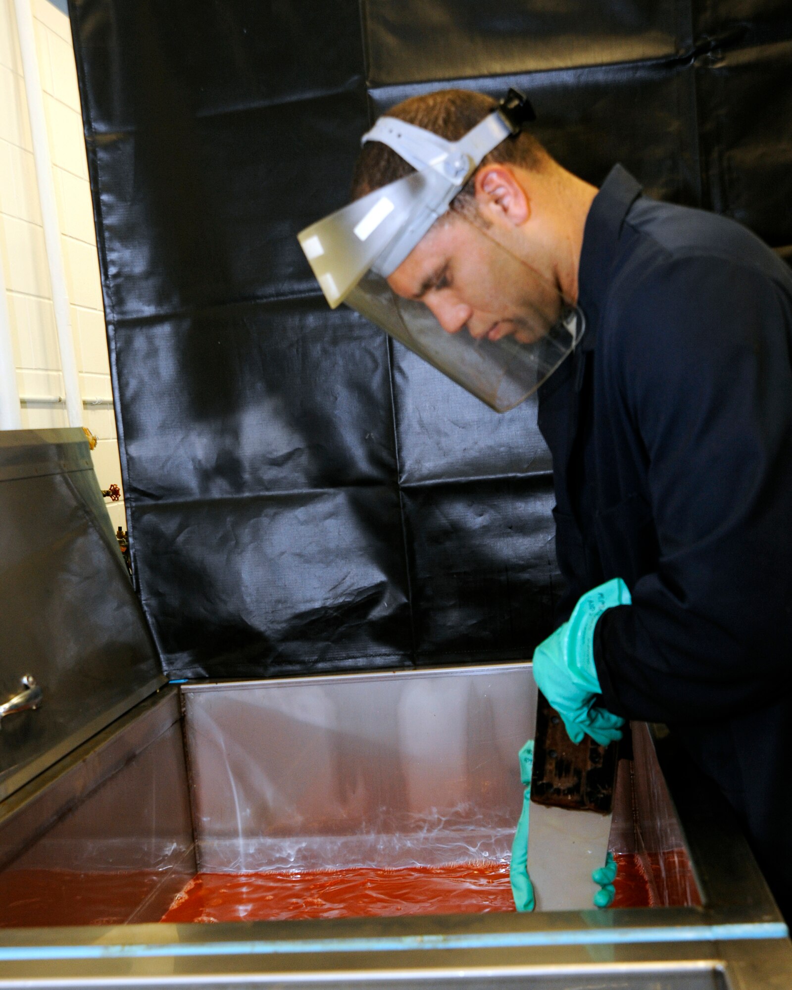 Staff Sgt. Cory Cuadrado, 6th Maintenance Squadron non-destructive inspection section chief, washes an aircraft part in a liquid solution. Sergeant Cuadrado, along with the other members of the Fabrication Flight, helps maintain the KC-135 Stratotankers. 
