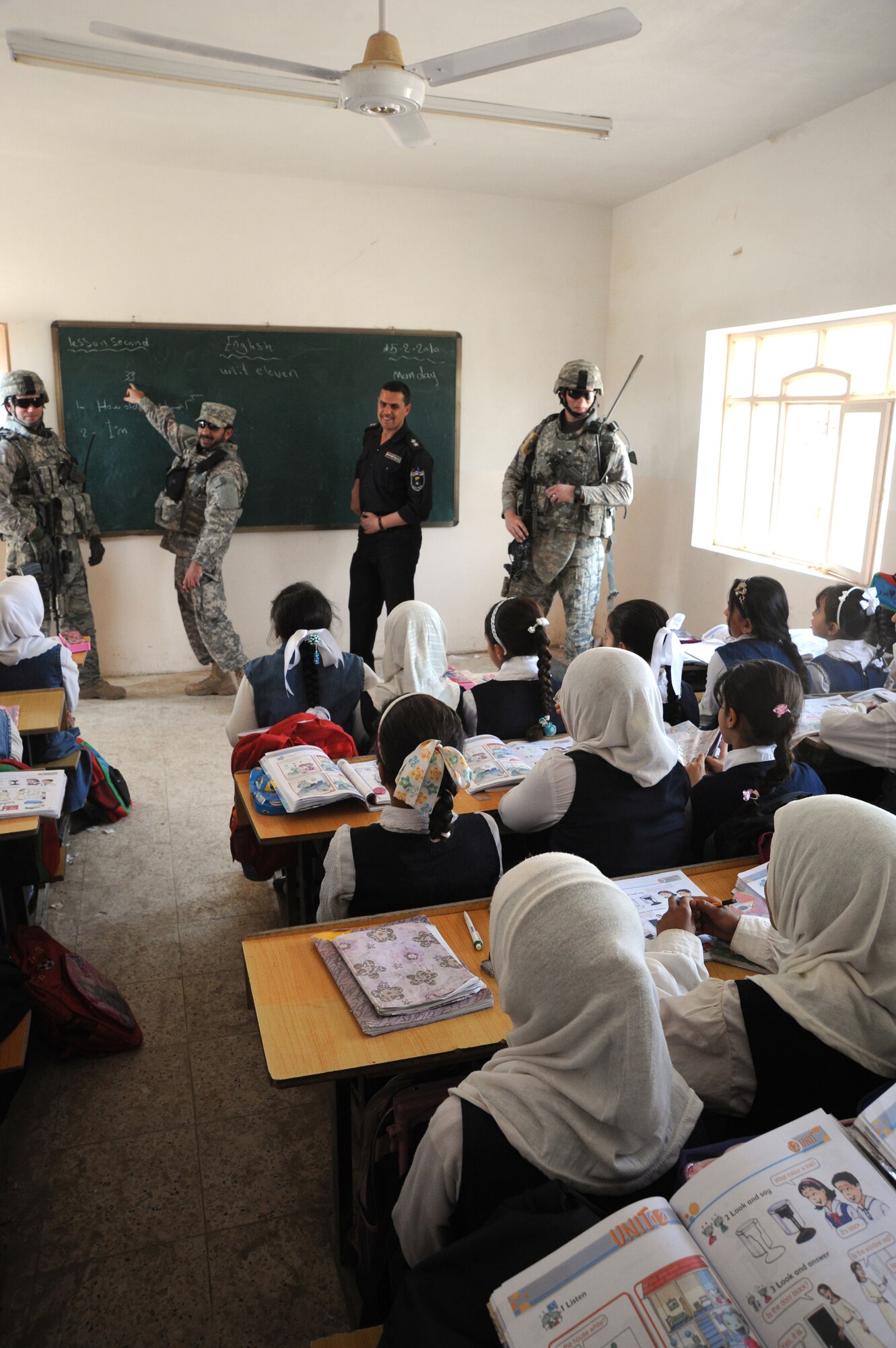 Air Force Tech. Sgt. Dennis Kuzel (left), Interpreter Nas (center), an Iraqi police officer, and Staff Sgt. Jared Winker, 732nd Expeditionary Security Forces Squadron Detachment 3, speak to school children while conducting a joint polling station assessment Feb 15, 2010.  The purpose of these assessments is to build a rapport between U.S. Forces and the Iraqi police, while providing key insights to force protection at polling sites for the March 7, elections. (U.S. Air Force photo/Master Sgt. Trish Bunting/Released)