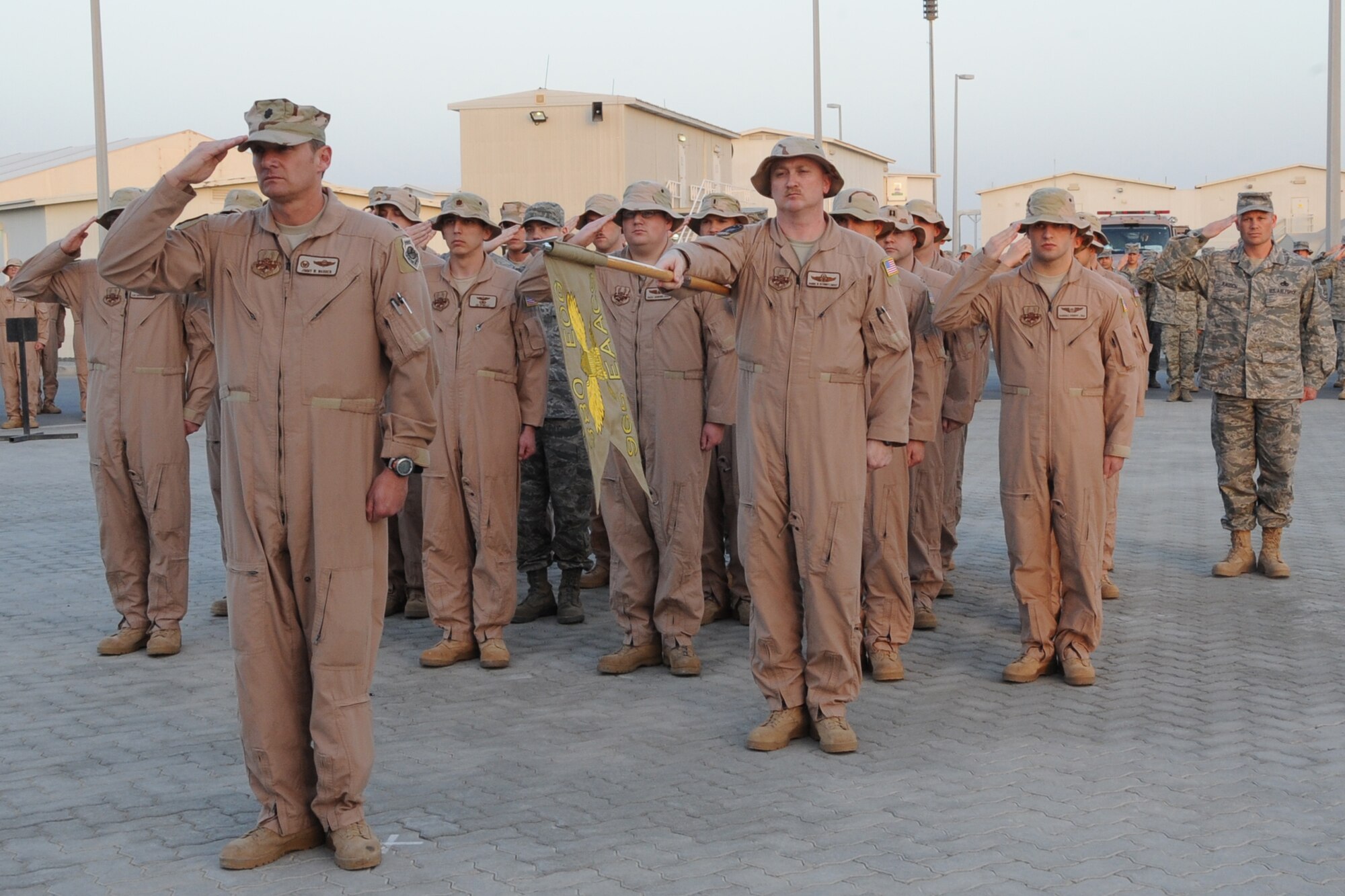 Members of the 965th Expeditionary Airborne Air Control Squadron salute during retreat at an undisclosed location in Southwest Asia on Feb. 19, 2010.  Airmen from across the 380th Air Expeditionary Wing join every week to pay respect during retreat. (U.S. Air Force photo/Senior Airman Jenifer H. Calhoun/Released)
