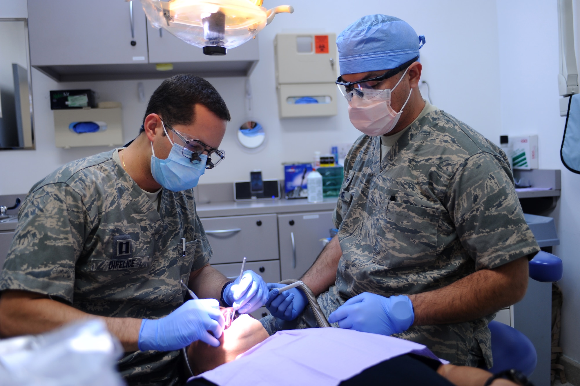 Capt. Michael DiFelice (left), 379th Expeditionary Medical Group dentist, works on a patient's dental filling while Staff Sgt. Rodrigo Lara, 379th EMDG dental technician, assists at a non-disclosed Southwest Asia location Feb. 15, 2010. (U.S. Air Force photo by Senior Airman Kasey Zickmund)[RELEASED]