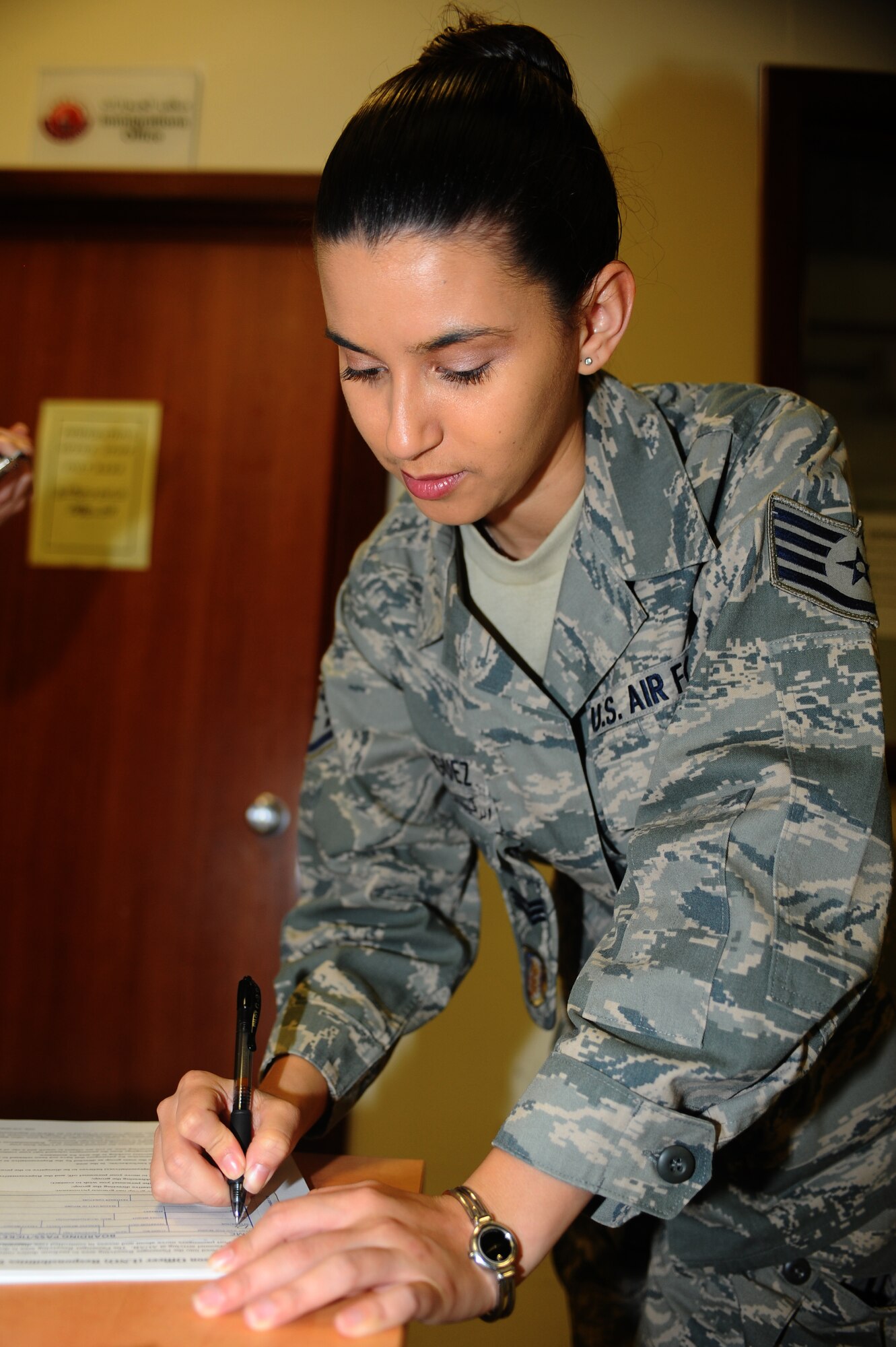 Staff Sgt. Diana Rodriguez, 379th Air Expeditionary Wing host-nation coordination cell liaison, fills out a boarding pass for a passenger at a non-disclosed Southwest Asia location Feb. 17, 2010. (U.S. Air Force photo by Senior Airman Kasey Zickmund)[RELEASED]