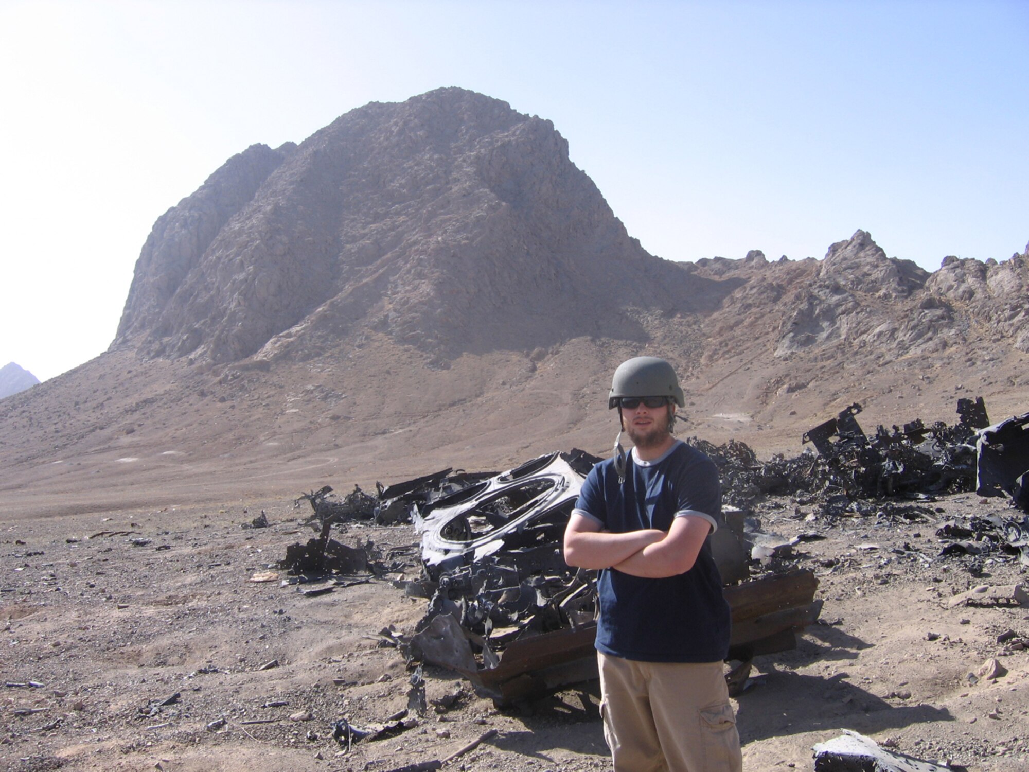 Senior Airman Andrew Blasiman, 100th Communications Squadron, poses on the demolition range at Firebase Maholic, Afghanistan. The Army special forces personnel he was working with taught him how to use demolitions safely and effectively. He said there are a lot of metal remnants around, including old vehicles, which are used for training purposes. (Courtesy photo)