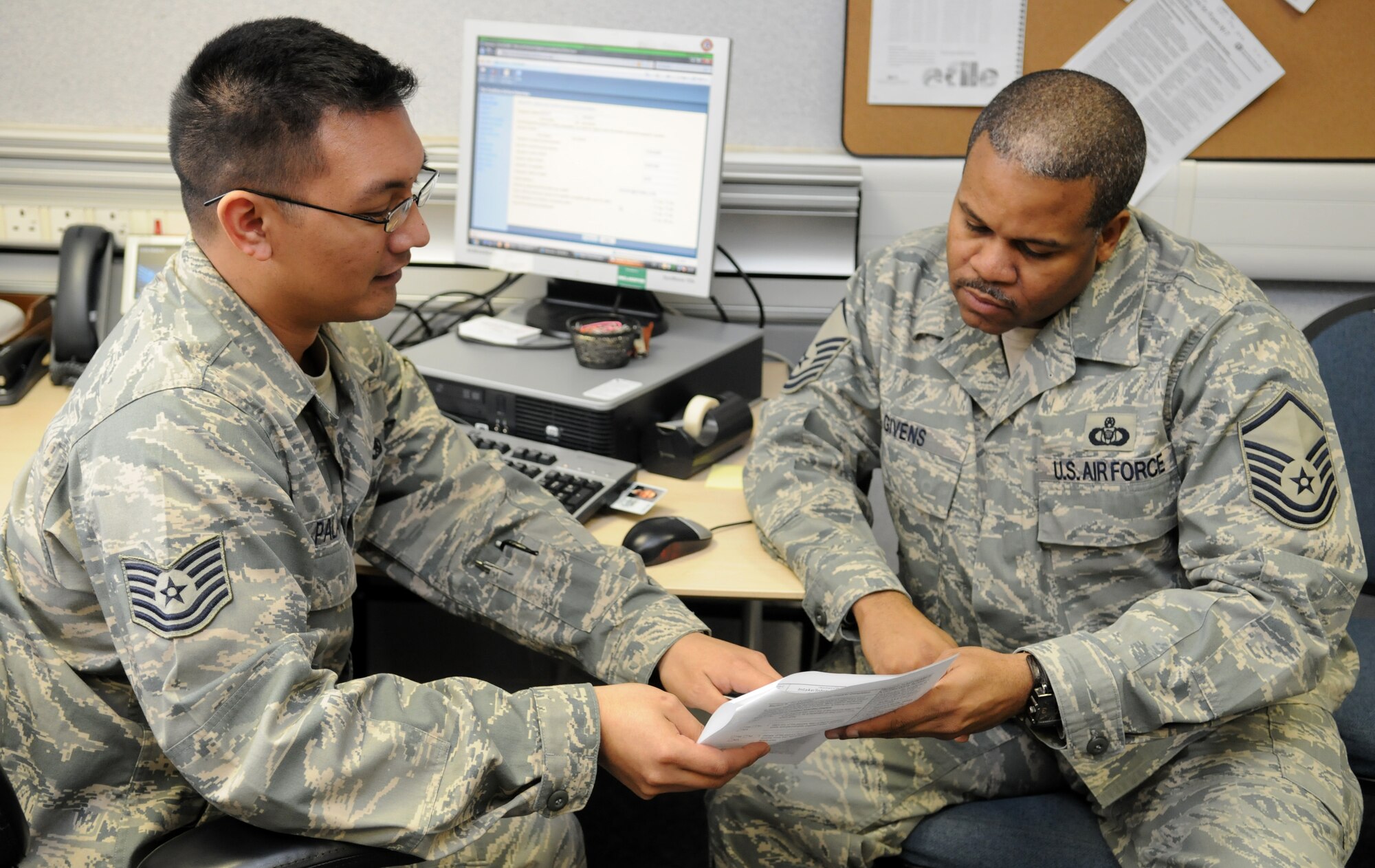 RAF MILDENHALL, England – Tech. Sgt. Moses Palaruan, 100th Air Refueling Wing legal office, provides tax return services to Master Sgt. Tevitt Givens, 100th Operation Support Squadron aviation resource manager, inside Bldg 424 Feb. 18. The tax centers hours of operation are 9 a.m. to noon and 1 p.m. to 4 p.m. Monday through Friday inside on the second floor of Bldg 424 until the end of the tax season June 15.  Simple returns for married or single Airmen can be made by emailing a W-2 to 100.ARW.taxcenter@mildenhall.af.mil .  The tax center is also looking for volunteers to help file taxes for more information contact Sergeant Palaruan at 238-1978. (U.S. Air Force Photo/ Staff Sgt. Jerry Fleshman)