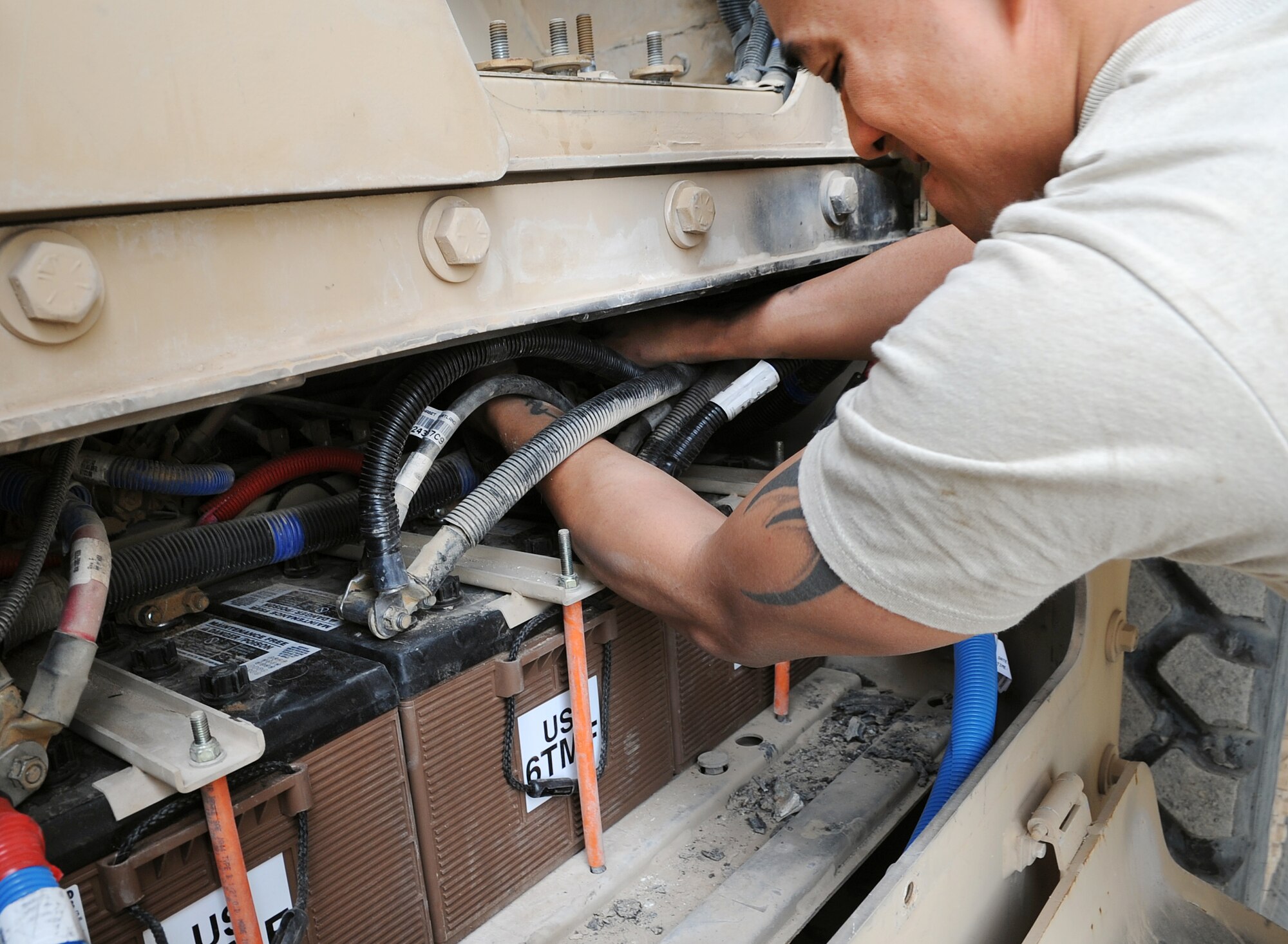 KIRKUK REGIONAL AIR BASE, Iraq –SrA Francisco Macatol, 506th Expeditionary Logistics Readiness Squadron vehicle maintainer, works on a Mine-Resistant Ambush-Protected Vehicle Feb. 12, 2010.  Airmen Macatol is upgrading the MRAP by installing a retro-kit for battery box. The vehicle maintenance shop has a hand in repairing just about any mission essential vehicle on base, including HMMWVs, forklifts, cargo loaders, dodge pickups, ambulances and fire trucks.  (U.S. Air Force photo/Staff Sgt. Tabitha Kuykendall)	    