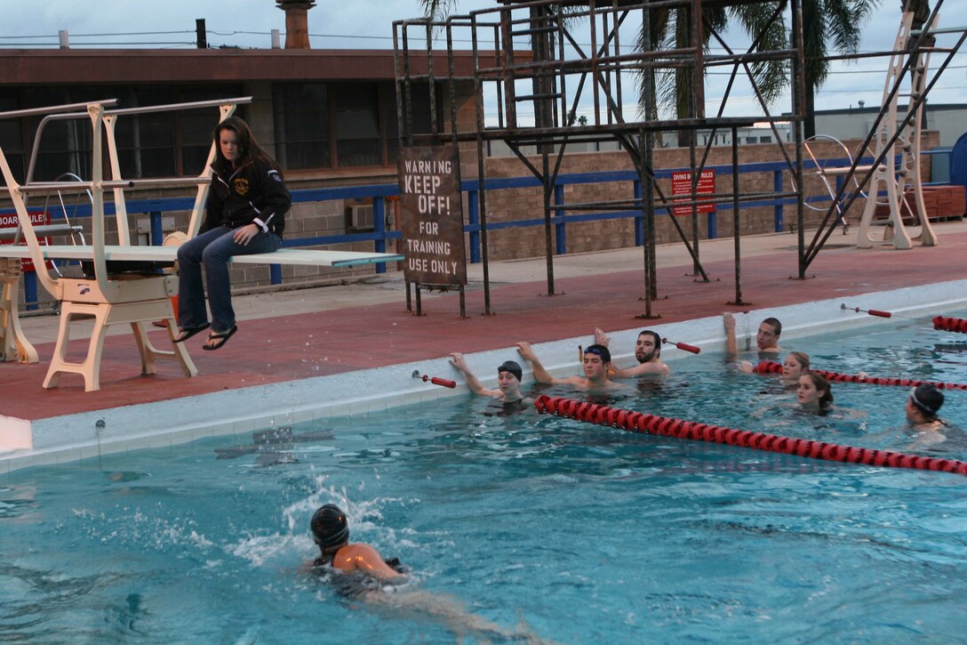 A student swims with a 10-pound brick during the 20-meter qualification of the MCCS sponsored American Red Cross Lifeguarding class at the 50-meter pool here Feb. 19. The students will be American Red Cross Certified lifeguards at the end of the course.