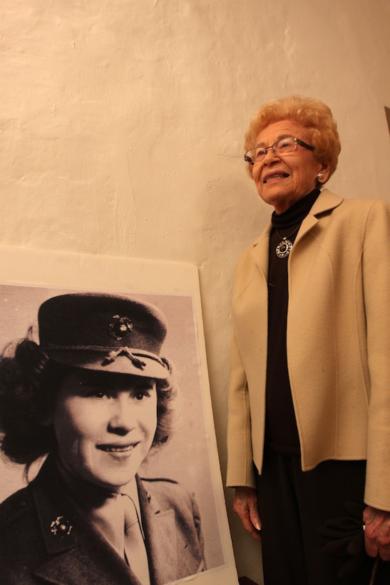 Alyce Williamson reminisces about the time she served as a Marine during World War II while standing next to an old service photo of her on display at the Camp Pendleton Santa Margarita Ranch House, Feb. 19. The 93-year-old was influenced to join the Marine Corps by a military campaign slogan of that time, “free a man to fight.” The photo is a part of a special exhibit to honor women Marines.
