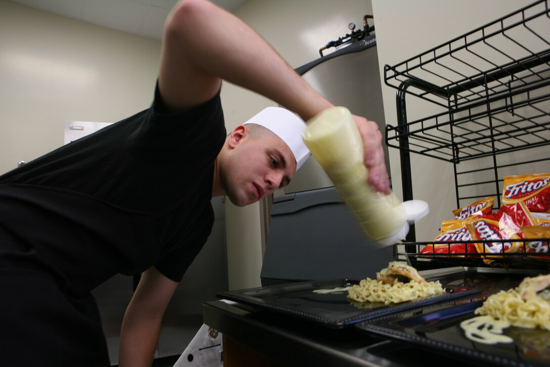 Cpl. Ian J. Sanders, 21, from Mount Pleasant, Mich., food service specialist with the 14 Area chow hall, Food Service Company, Combat Logistics Regiment 17, 1st Marine Logistics Group, prepares his spinach and cheese stuffed chicken and herb seasoned noodles to be judged at the Marine Corps Installations – West Chow Hall of theQuarter competition at Camp Las Flores dinning facility, Feb. 18. Eight teams throughout the west coast competed in the two-day cook-off to represent their chow hall with hopes of taking home the gold.