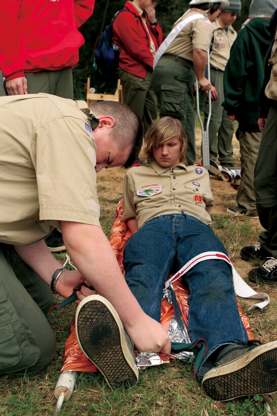 Ryan Steele, 15, applies a splint on the leg of simulated casualty, Luke Board, 16, during the Boy Scouts of America's Klondike Derby at Kin Blue Training Area Feb. 20. The Boy Scouts were tested on various skills including first aid.