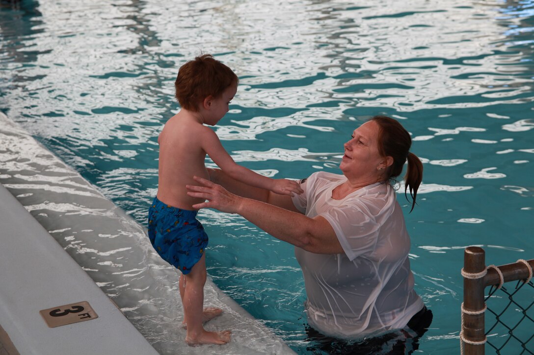 Terri Fisher, the aquatics director for Cherry Point, assist a member of the Exceptional Family Member Program’s swim class jump into the Cherry Point’s combat pool Feb. 20. The EFMP is conducting these classes as a trail run with the goal of changing it to a year round program.