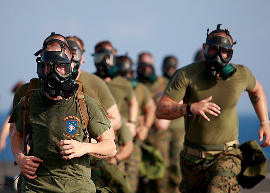 U.S. Marines assigned to the 31st Marine Expeditionary Unit run while wearing gas masks during physical training on the flight deck of USS Harpers Ferry (LSD 49) Feb. 21, 2010, while under way in the South China Sea. Harpers Ferry is a part of the forward-deployed Essex Amphibious Ready Group and is conducting a spring patrol to the western Pacific Ocean.