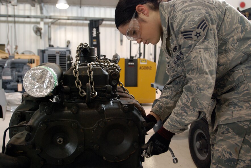 Members of the 433rd Aerospace Ground Equipment Flight work on replacing an engine in an A/M 32A-86 generator. The engines power C-5 cargo aircraft when they are parked on the ramp. Senior Airman Amanda Quintanilla removes parts from an old engine to install on a new one before the engine goes in a generator. (U.S. Air Force photo/Airman 1st Class Brian McGloin)
