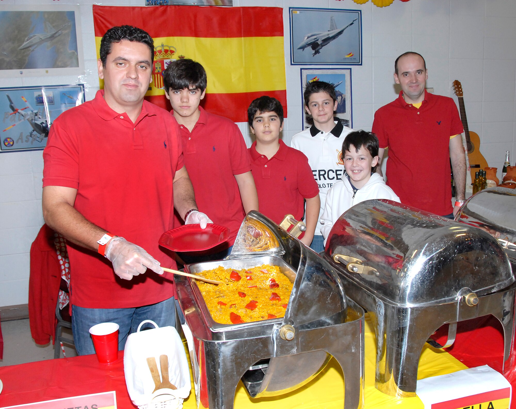 Members of the 80th Flying Training Wing Euro-NATO Joint Jet Pilot Training program serve food from Spain at the ENJJPT Around the World party at the Community Center Feb. 19. (U.S. Air Force photo/Harry Tonemah)

