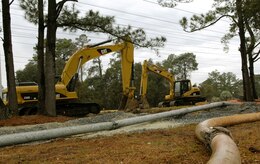 Construction vehicles contracted by the North Charleston Sewer District work to clean a sewage spill Feb. 22 from the field near the youth center here after a sewer line broke Feb. 21. It was estimated more than 5,000 gallons of sewage was released. Multiple construction companies were contracted out by the NCSD to assist in cleaning up the field. (U.S. Air Force photo/Airman 1st Class Lauren Main)