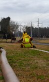 Workers from Eadies Construction Inc. unroll a hose Feb. 22 to pump sewage from the field near the youth center here after a sewer line broke Feb. 21. While the line is on base, it is still maintained by the North Charleston Sewer District. Multiple construction companies were contracted out by the NCSD to assist in cleaning up the field and to ensure the proper precautions are put in place to maintain a sanitation standard. (U.S. Air Force photo/Airman 1st Class Lauren Main)