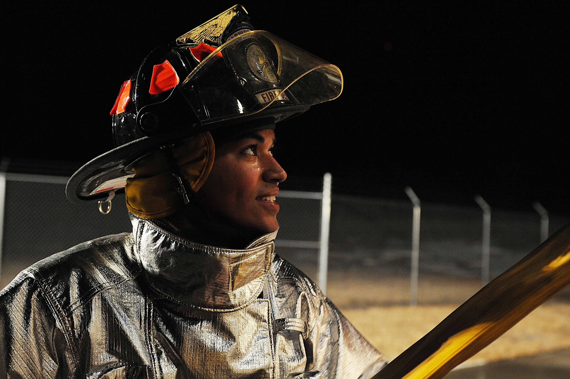 ELLSWORTH AIR FORCE BASE S.D.-- Airman 1st Class Charles Carreras, 28th Civil Engineer Squadron firefighter, helps roll a hose into a fire truck during a night structural fire training exercise, Feb. 17. Ellsworth’s fire department trains every day to respond to emergencies. (U.S. Air Force photo/Airman 1st Class Corey Hook)