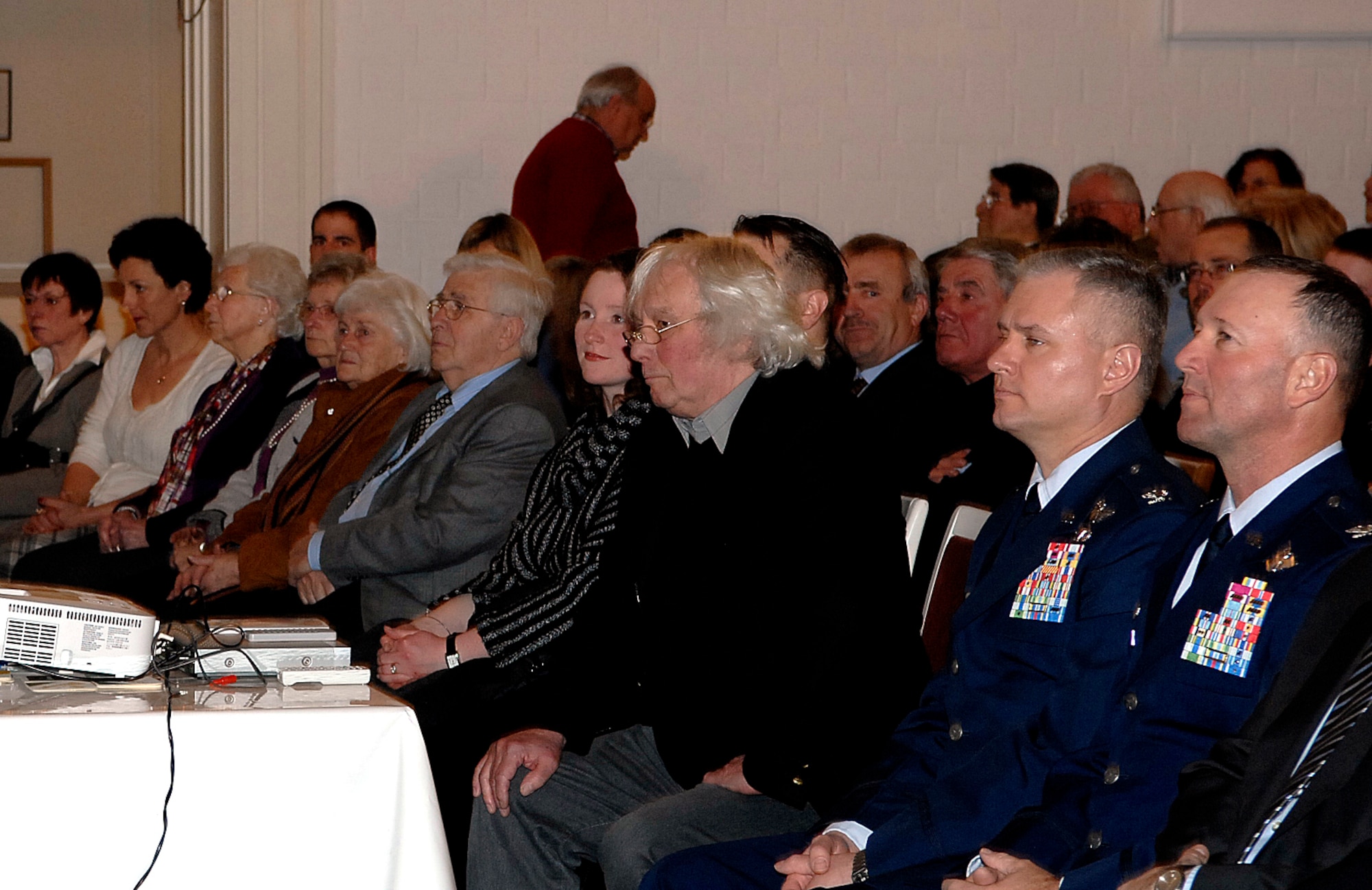 BITBURG, Germany – Hansjuergen Hilgert (middle) sits next to Col. Kevin Anderson, 52nd Fighter Wing vice commander, and Col. Tip Wight, 52nd Fighter Wing commander, during the debut of his film, “Spangdahlem, Bitburg and the Base,” Feb. 19. The 30-minute documentary shows the relationships between Spangdahlem Air Base and surrounding local German communities since World War II. The film includes footage of base operations, on- and off-base locations and events, as well as personal stories from Americans and Germans alike. (U.S. Air Force photo/2nd Lt. Kathleen Polesnak)