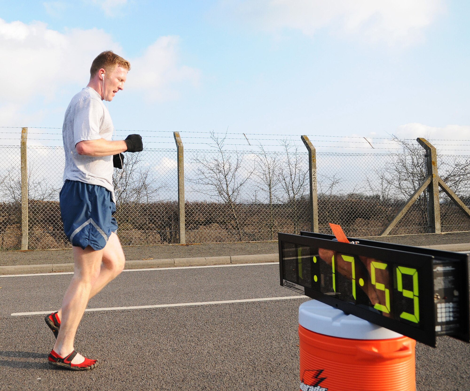 RAF MILDENHALL, England -- An RAF Mildenhall Airman finishes the Team Mildenhall 5K Fun Run with a time of 17 minutes, 59 seconds near the Hardstand Fitness Center Feb. 19. Hundreds of 100th Air Refueling Wing and tenant unit Airmen participated in the monthly run. Families, friends and even pets were encouraged to attend to promote health and fitness. (U.S. Air Force photo/Senior Airman Thomas Trower)