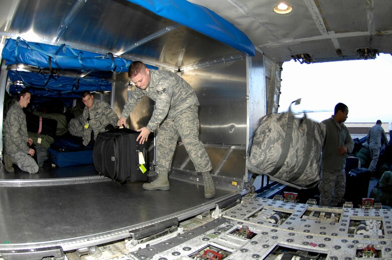 WHITEMAN AIR FORCE BASE, Mo. - Team Whiteman members load luggage Feb. 18, 2010 here, on an aircraft headed for Andersen AFB, Guam. More than 200 Airmen deployed in support of the B-2 Spirit's continuing bomber presence in the Pacific. (U.S. Air Force photo/Staff Sgt. Jason Barebo)