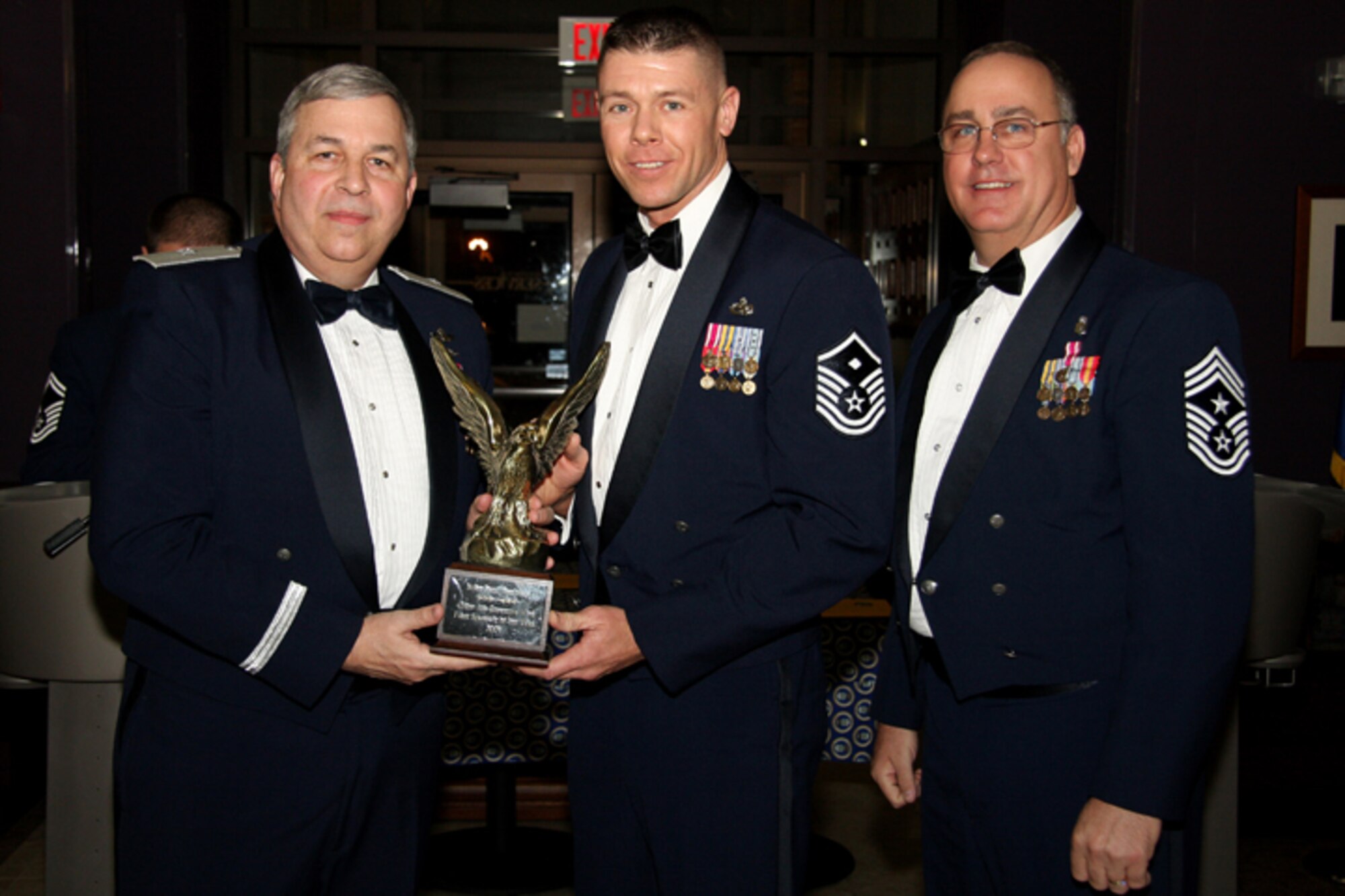 GRISSOM AIR RESERVE BASE, Ind. --  Master Sgt. Paul Tomlinson, 434th Services Flight first sergeant, receives a trophy in recognition for being named 434th Air Refueling Wing First Sergeant of the Year from Brig. Gen. Dean Despinoy, 434th ARW commander, and Chief Master Sgt. Larry Brady, 434th ARW command chief. Trophies and recognition were given out during the annual awards banquet dinner held recently at the base dining facility. Military personnel, Grissom Community Council members and families were in attendance. (U.S. Air Force photo/Tech. Sgt. Mark. R. W. Orders-Woempner)