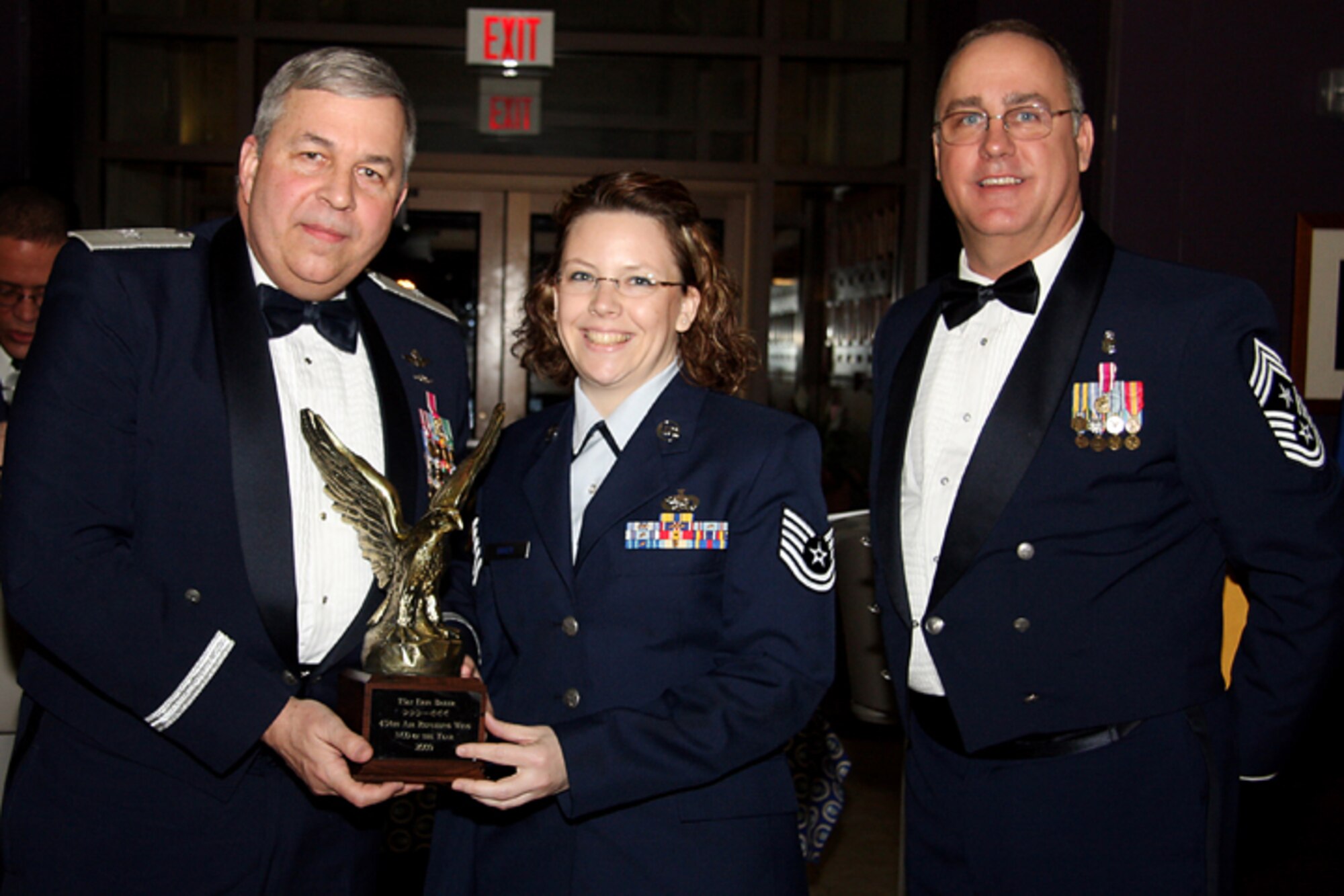 GRISSOM AIR RESERVE BASE, Ind. -- Tech. Sgt. Erin Baker, 434th Logistics Readiness Squadron logistics plans technician, receives a trophy in recognition for being named 434th Air Refueling Wing Noncommissioned Officer of the Year from Brig. Gen. Dean Despinoy, 434th ARW commander, and Chief Master Sgt. Larry Brady, 434th ARW command chief. Trophies and recognition were given out during the annual awards banquet held at the base dining facility. Military personnel, Grissom Community Council members and families were in attendance. (U.S. Air Force photo/Tech. Sgt. Mark. R. W. Orders-Woempner)