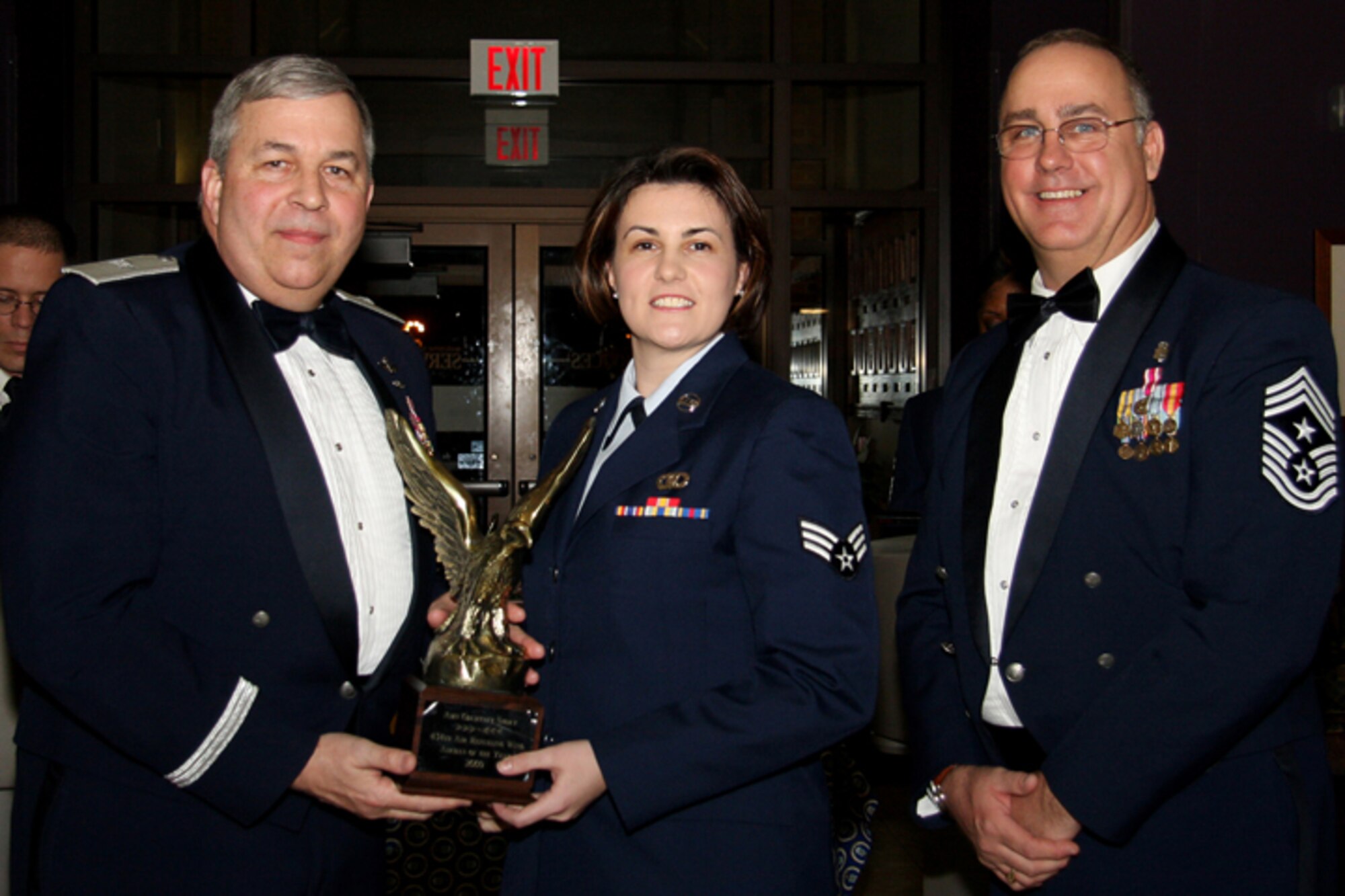 GRISSOM AIR RESERVE BASE, Ind. -- Senior Airman Courtney Storey, 434th Operations Support Squadron flight management apprentice, receives a trophy in recognition for being named 434th Air Refueling Wing Airman of the Year from Brig. Gen. Dean Despinoy, 434th ARW commander, and Chief Master Sgt. Larry Brady, 434th ARW command chief. Trophies and recognition were given out during the annual awards banquet held recently at the base dining facility. Military personnel, Grissom Community Council members and families were in attendance. (U.S. Air Force photo/Tech. Sgt. Mark. R. W. Orders-Woempner)