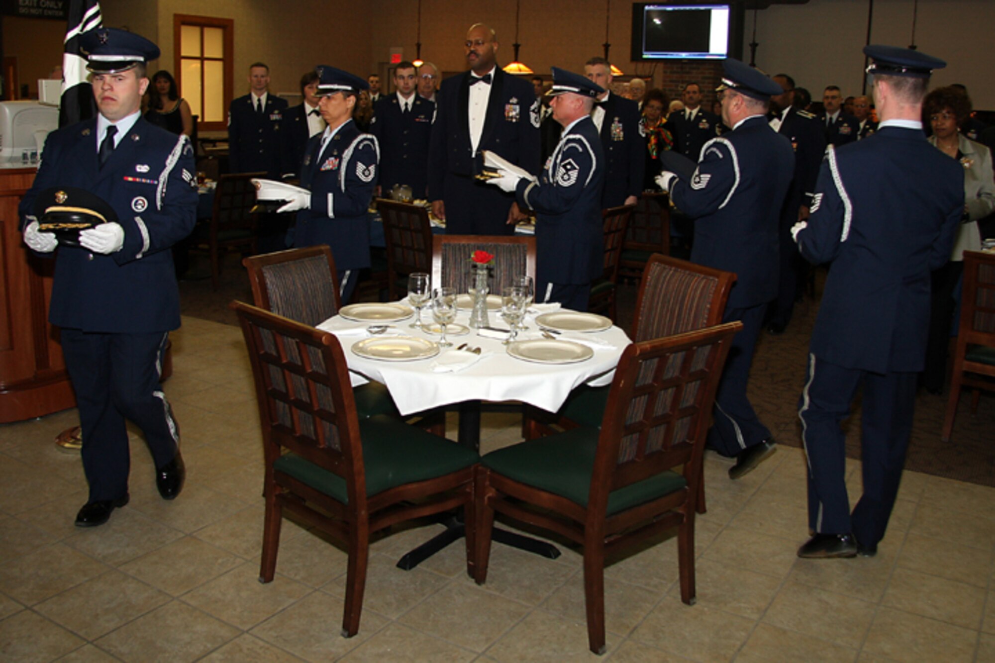 GRISSOM AIR RESERVE BASE, Ind. -- Members of the Grissom Base Honor Guard circle a table in honor of prisoners of war and those missing in action during a POW/MIA ceremony held during the opening ceremonies of the annual awards banquet held recently at the base dining facility. The banquet honored 434th Air Refueling Wing annual award winners and was held at the Grissom dining facility. (U.S. Air Force photo/Tech. Sgt. Mark. R. W. Orders-Woempner)