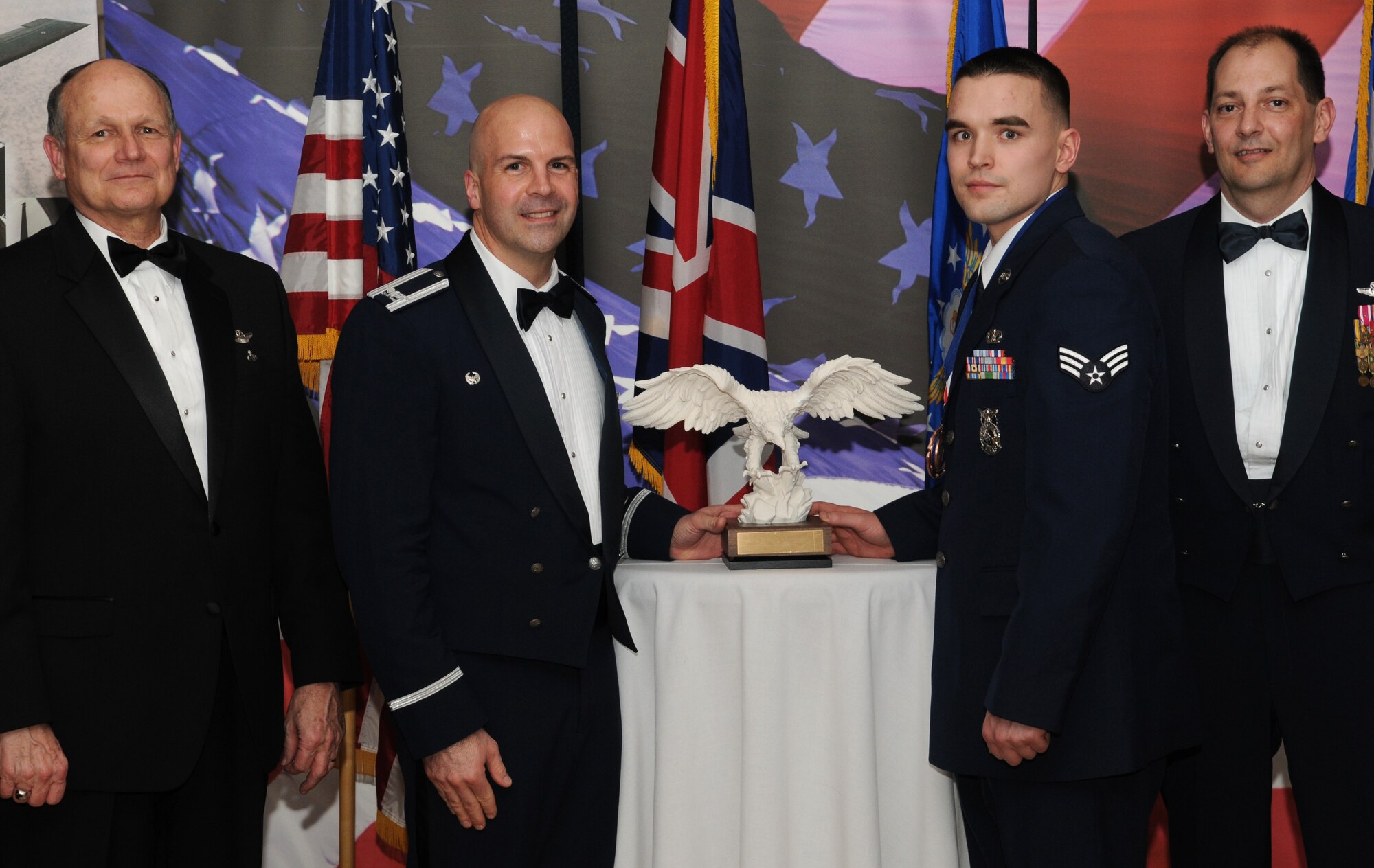 RAF MILDENHALL, England -- Senior Airman Kristopher Peterson, 100th Civil Engineer Squadron fire fighter, is the 100th Air Refueling Wing 2009 Airman of the Year. His achievements over the past year included providing emergency care to Iraqi civilians while deployed and saving the life of a three-story fall victim. He also volunteered 35 hours at the Joint Base Balad, Iraq, Air Force Theater Hopsital. He is presented this award by retired Gen. Gregory Martin, Col. Chad Manske, 100th ARW commander, and Chief Master Sgt. Antonio Hickey, 100th ARW command chief. (U.S. Air Force photo/Senior Airman Thomas Trower)