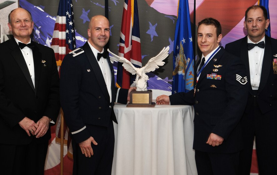 RAF MILDENHALL, England -- Staff Sgt. Michael Lauria, 321st Special Tactics Squadron, is the Team Mildenhall 2009 Airman of the Year. His achievements over the past year include flying on 34 missions with a joint task force and assisting in the capture of 30 high-value terrorists. He also rushed to a crashed helicopter to help move five Army crewmembers to safety. He also taught first aid skills to a local Boy Scouts of America troop. He is presented this award by retired Gen. Gregory Martin, Col. Chad Manske, 100th Air Refueling Wing commander, and Chief Master Sgt. Antonio Hickey, 100th ARW command chief. (U.S. Air Force photo/Senior Airman Thomas Trower) 