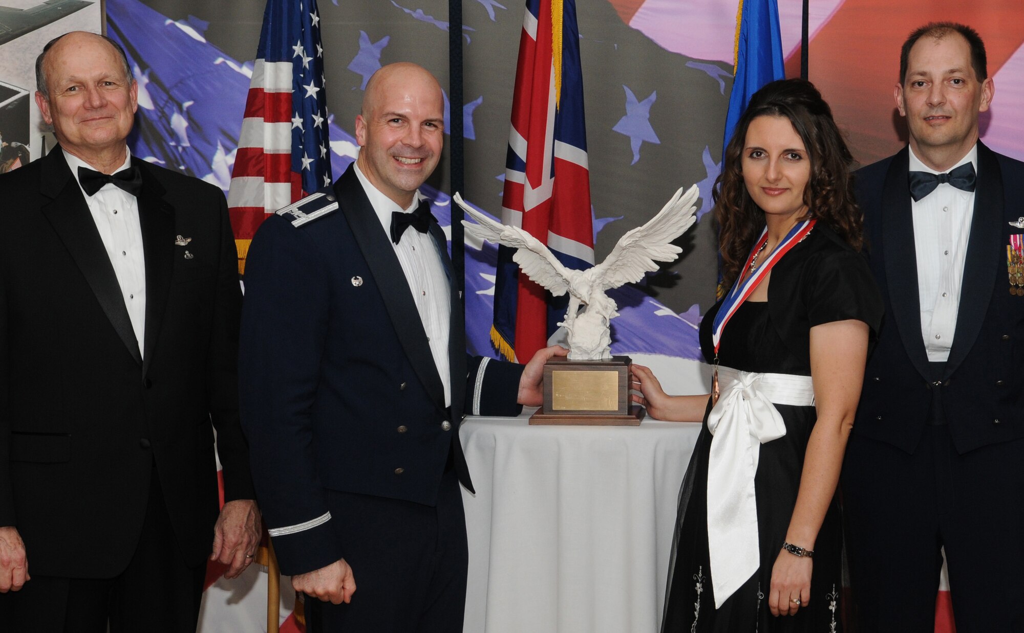 RAF MILDENHALL, England -- Virna Russell, 100th Force Support Squadron human resources specialist, is the 100th Air Refueling Wing and Team Mildenhall 2009 Civilian Supervisor of the Year. Her accomplishments include auditing 110 employee pay records and creating a 92-page human resource training manual. She also ran a clothing drive to collect and donate more than 100 outfits for Afghan women and children. She is presented this award by retired Gen. Gregory Martin, Col. Chad Manske, 100th ARW, and Chief Master Sgt. Antonio Hickey, 100th ARW command chief. (U.S. Air Force photo/Senior Airman Thomas Trower) 