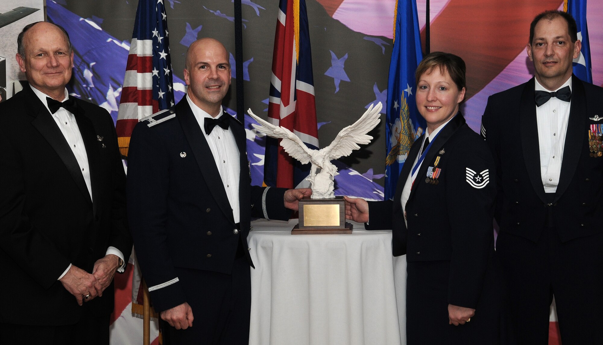 RAF MILDENHALL, England -- Tech. Sgt. Rebecca Janssen, 488th Intelligence Squadron network operations superintendent, is the Team Mildenhall Volunteer of the Year. Her volunteer efforts include serving as a committee member for Ride for Life to organize 60 volunteers and raise more than $24,000 for United Kingdom child's hospice. She also actively participated as the vice president of the Air Force Sergeant's Association local chapter. She is presented this award by retired Gen. Gregory Martin, Col. Chad Manske, 100th Air Refueling Wing commander, and Chief Master Sgt. Antonio Hickey, 100th ARW command chief. (U.S. Air Force photo/Senior Airman Thomas Trower)