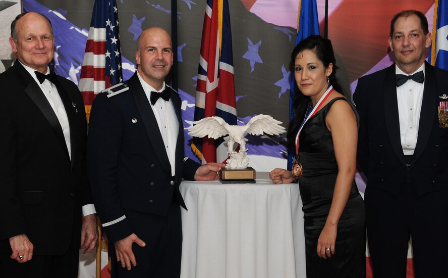 RAF MILDENHALL, England -- Fabiola Flores, 100th Comptroller Squadron budget analyst, is the 100th Air Refueling Wing 2009 Civilian Category I of the Year. Her accomplishments include closing out $68 million in tenant budgets with zero errors and providing budget support to the 352nd Special Operations Group. She also organized a 5K run to raise awareness for the Sexual Assault Response Program. She is presented this award by retired Gen. Gregory Martin, Col. Chad Manske, 100th ARW commander, and Chief Master Sgt. Antonio Hickey, 100th ARW command chief. (U.S. Air Force photo/Senior Airman Thomas Trower) 
