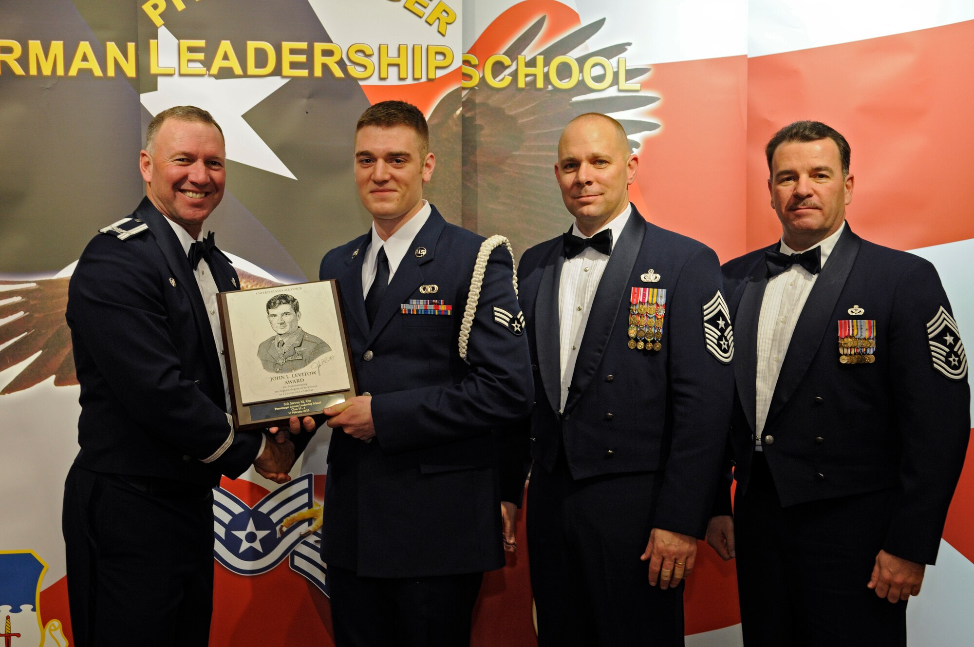 SPANGDAHLEM AIR BASE, Germany – Col. Tip Wight, 52nd Fighter Wing commander; Chief Master Sgt. Dennis Vannorsdall, 3rd Air Force command chief, and Chief Master Sgt. Randall Marshall, Sr., 521st Air Mobility Operations Wing command chief, Ramstein Air Base, Germany present Senior Airman Steven Ott, 52nd Operations Support Squadron, the John L. Levitow Award during the graduation of the Pitsenbarger Airman Leadership School Class 10-3 in the Club Eifel Feb. 17. The John L. Levitow award is the highest level award an Airman can receive upon completion of ALS. (U.S. Air Force photo/Senior Airman Benjamin Wilson)