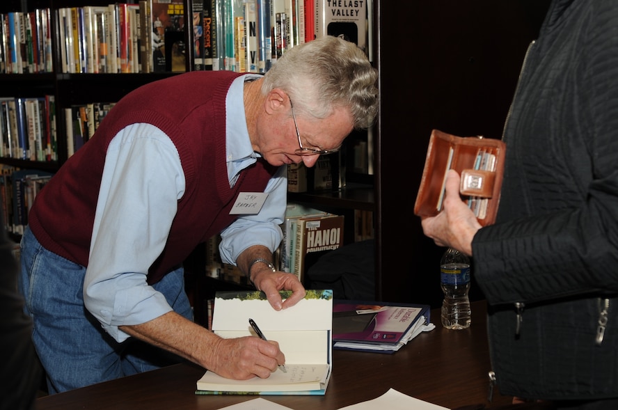 Jasper E. Barber, author of "Memories of the Islands," signs his book during a Meet the Author book signing on Seymour Johnson Air Force Base, Feb. 18, 2010. During the book signing Barber, along with three other writers, explained the storylines behind their books.  Barber is a retired Air Force senior master sergeant who lives with his wife in Goldsboro, N.C. (U.S. Air Force photo/Staff Sgt. Courtney Richardson) 