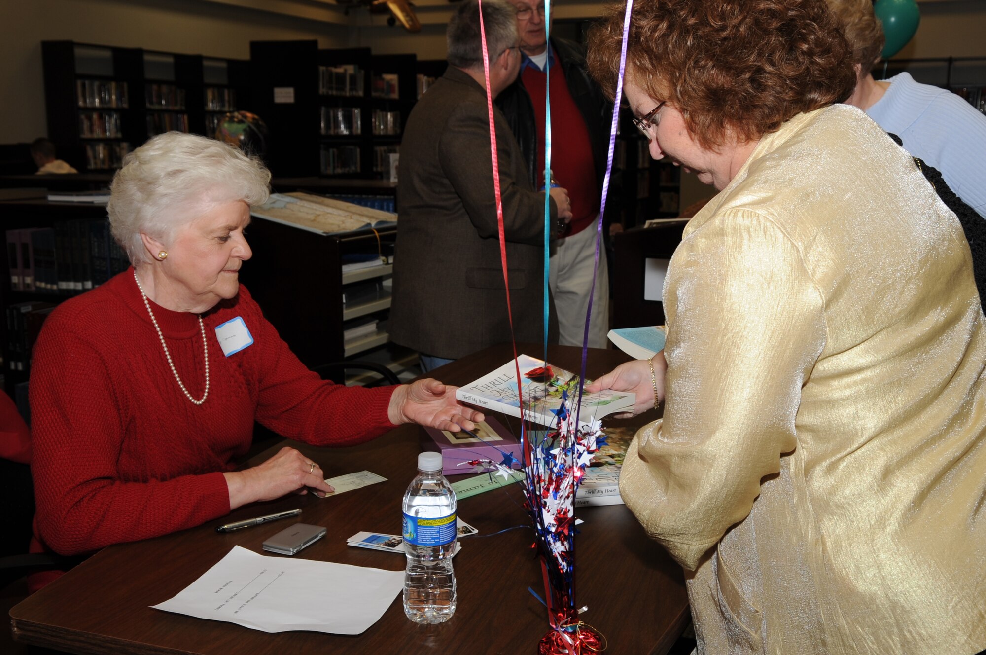 Jo James, author of "Be Still My Heart," sells a copy of her book during a Meet the Author book signing on Seymour Johnson Air Force Base, Feb. 18, 2010. During the book signing the authors explained their affiliation to the military and answered questions regarding their lives and the books. James, a 35-year Air Force spouse, lives in the Blue Ridge Mountains of Virginia. (U.S. Air Force photo/Staff Sgt. Courtney Richardson) 